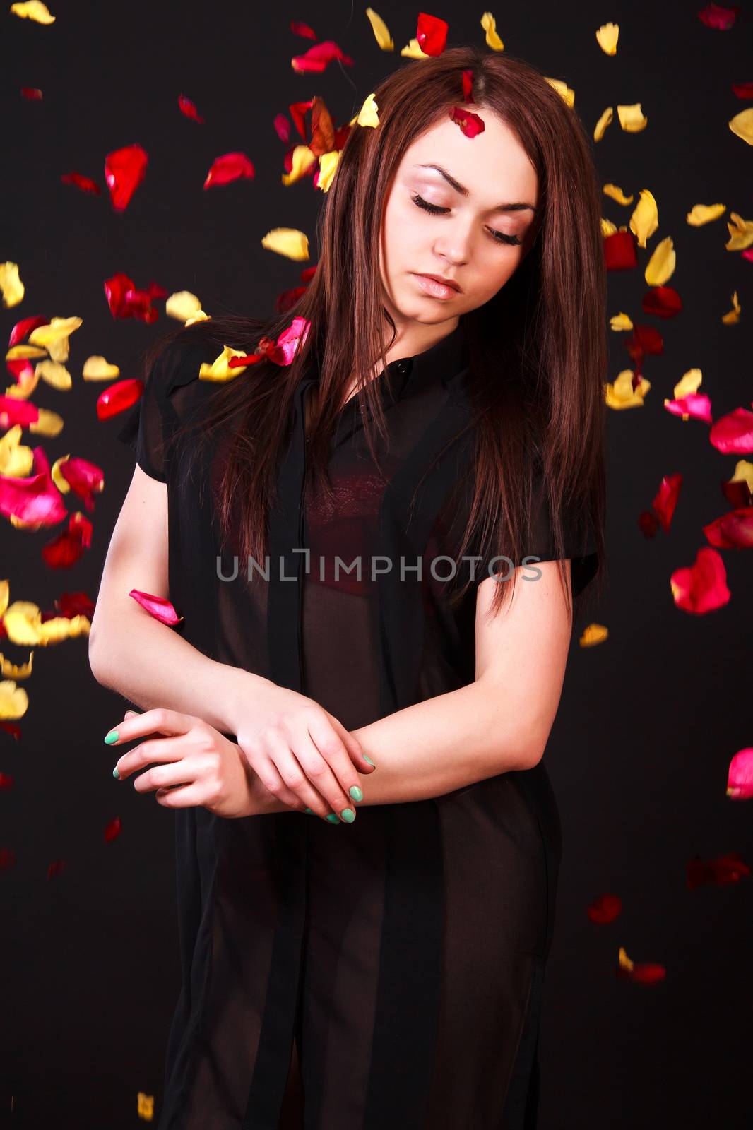 Beautiful young woman staying under the falling petals by Artzzz