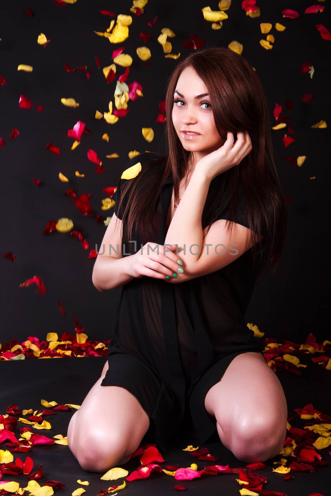 Beautiful young woman sitting under the falling petals by Artzzz