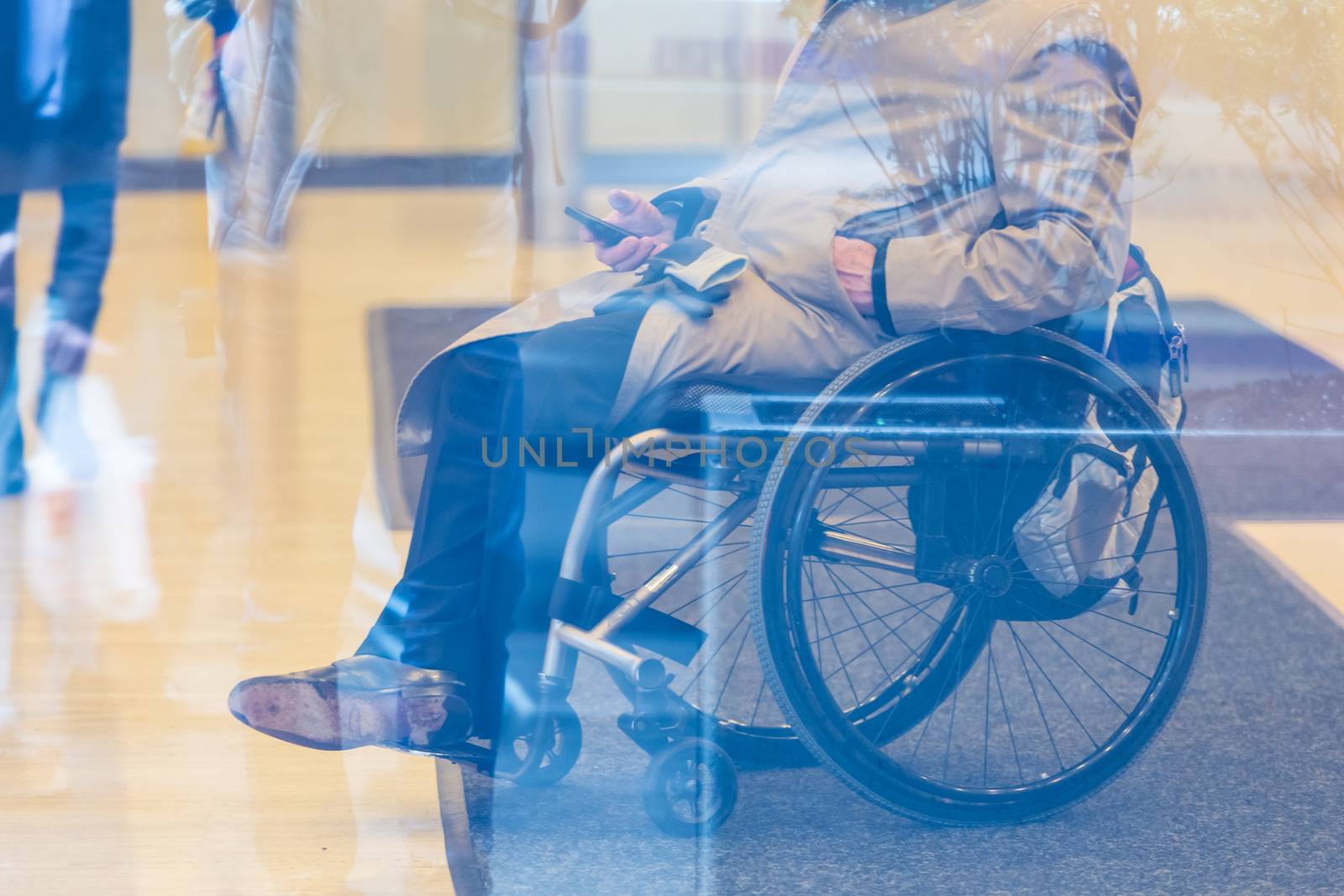 Handicapped male businessman on a wheelchair using smartphone. Disabled people active for life.