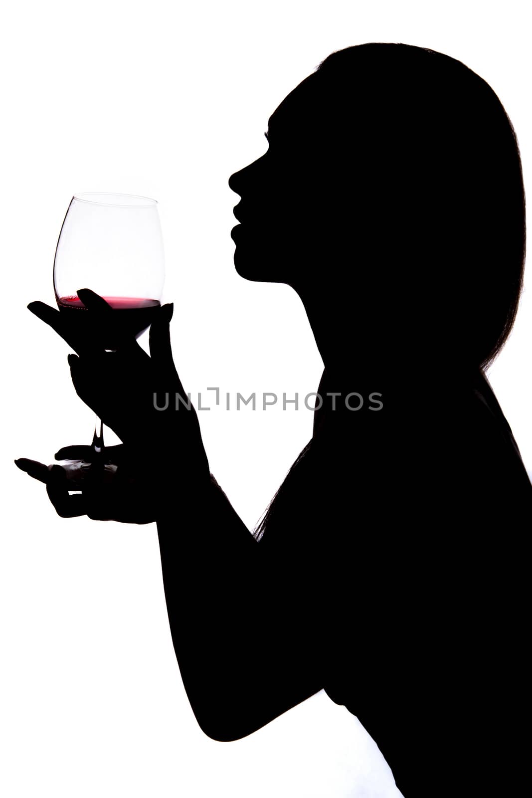 Silhouette of a woman holding the wineglass