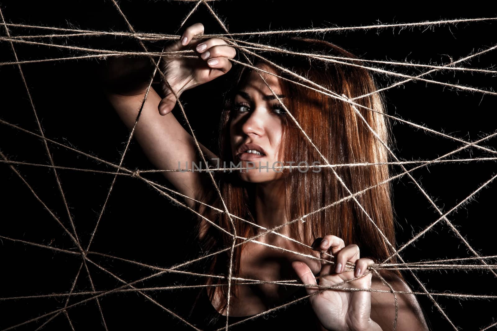 Beautiful young woman behind the interlaced ropes by Artzzz