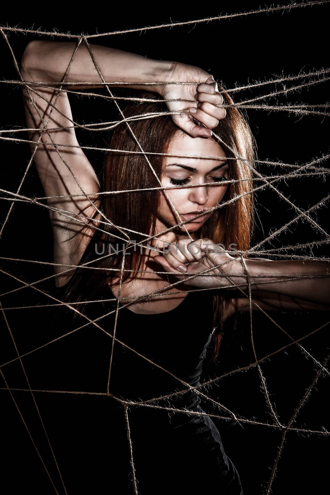 Beautiful young woman behind the interlaced ropes by Artzzz