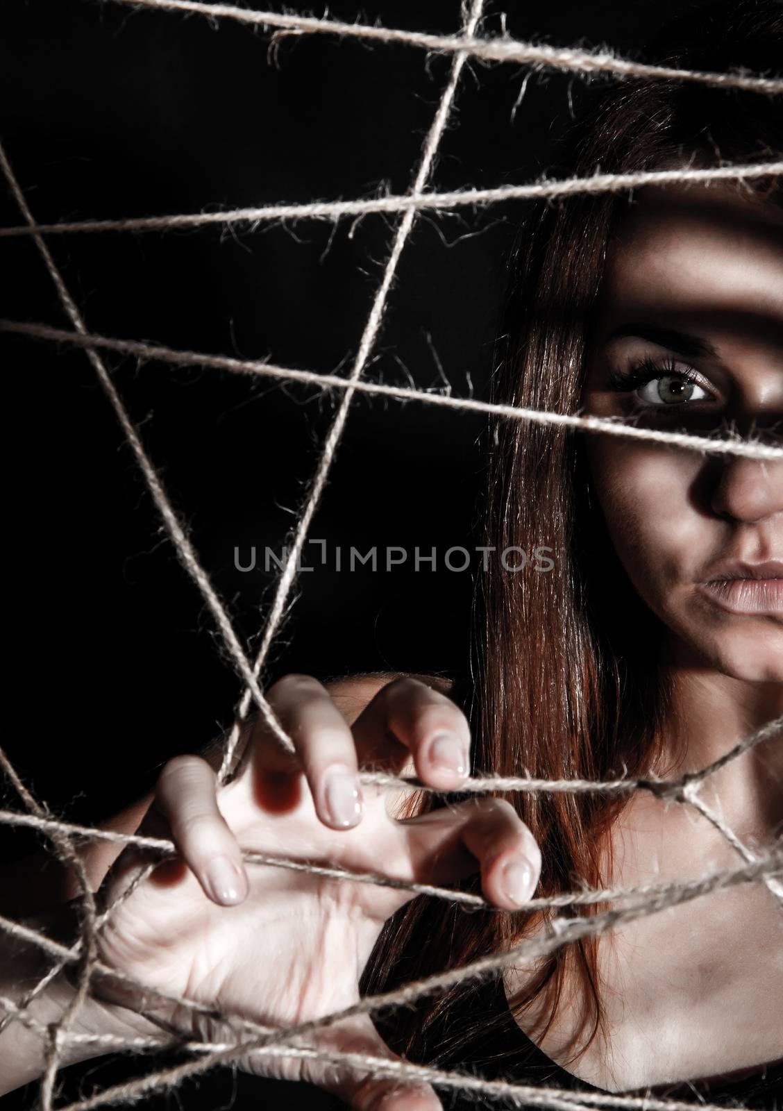 Beautiful young woman behind the interlaced ropes by Artzzz