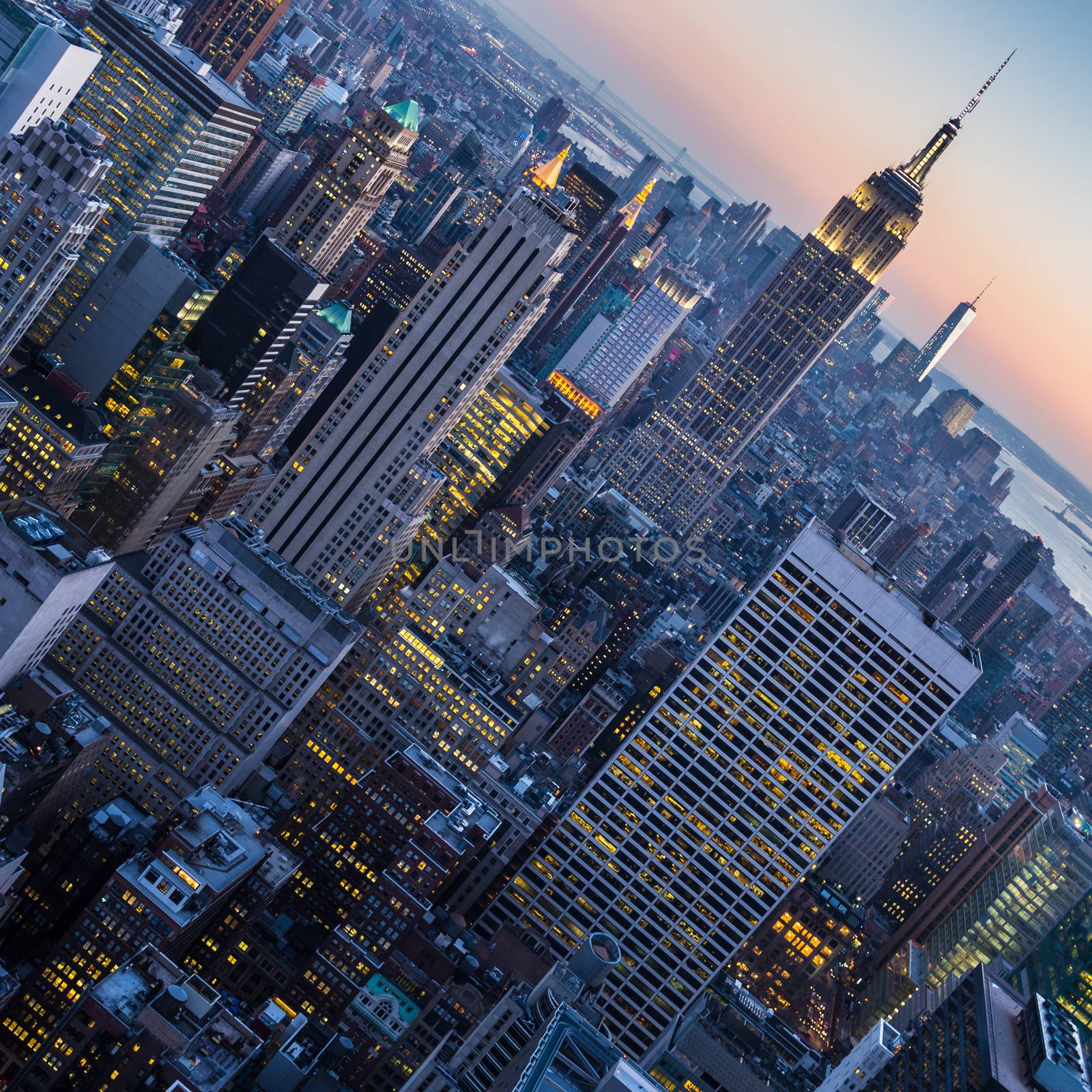 New York City. Manhattan downtown skyline with illuminated Empire State Building and skyscrapers at dusk.