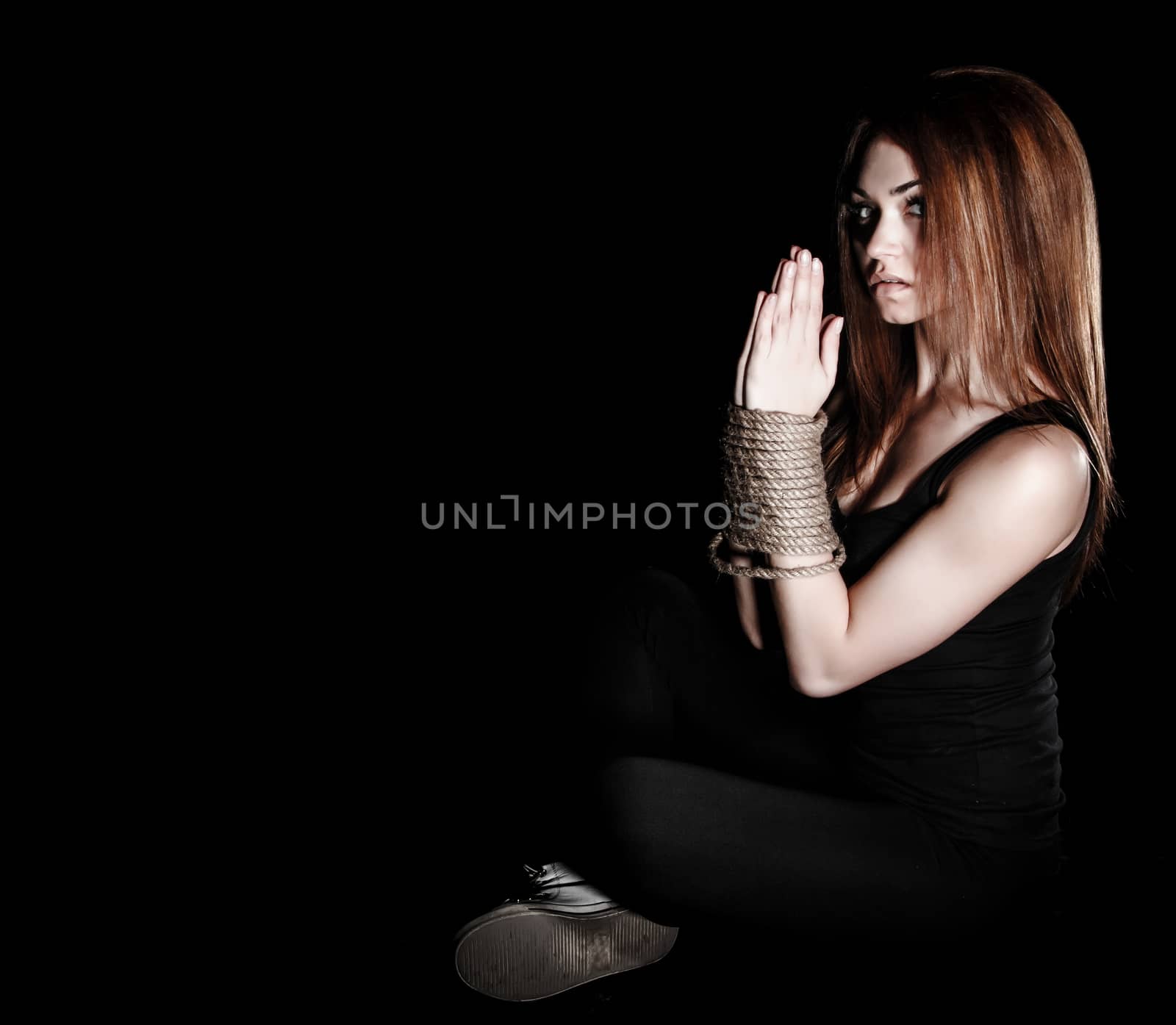 Beautiful young woman with tied arms sitting on the floor by Artzzz