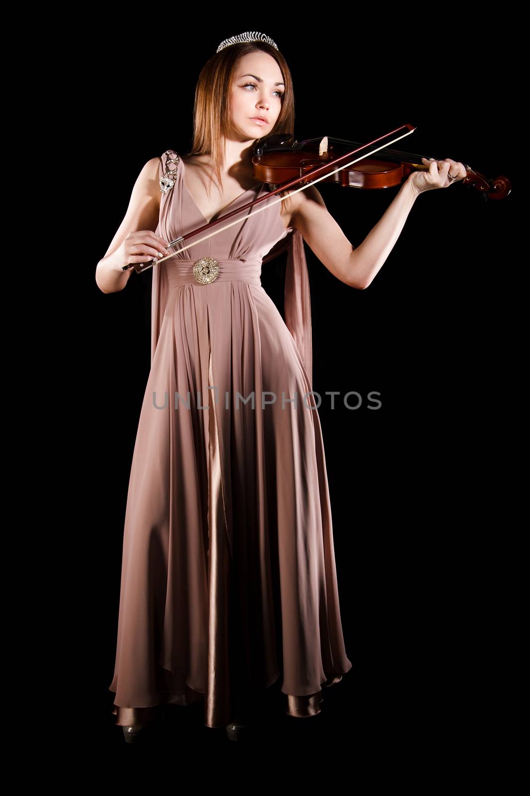 Pretty young woman playing a violin over black background