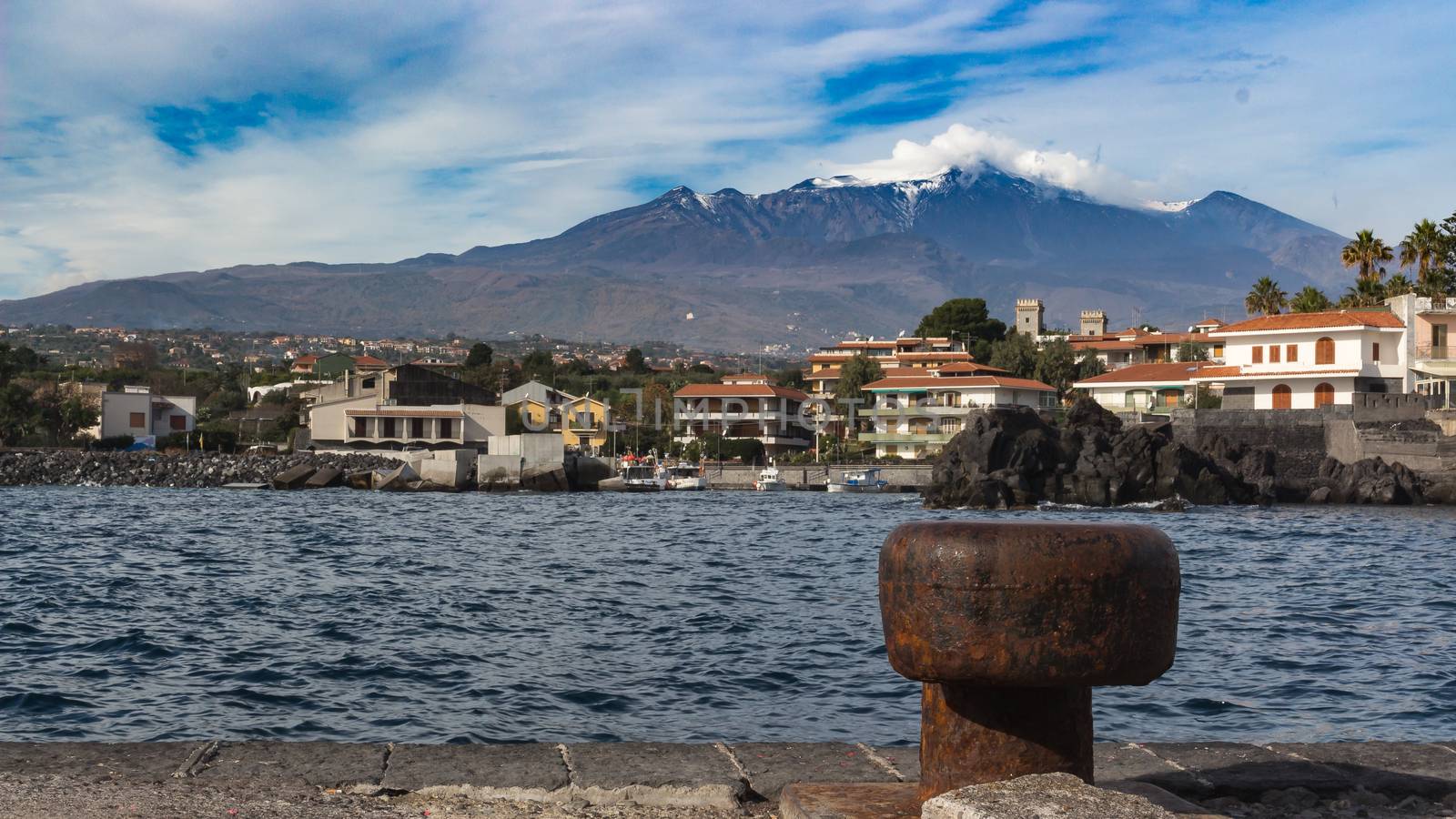 View of Sea port in sicily whit volcano Etna in background