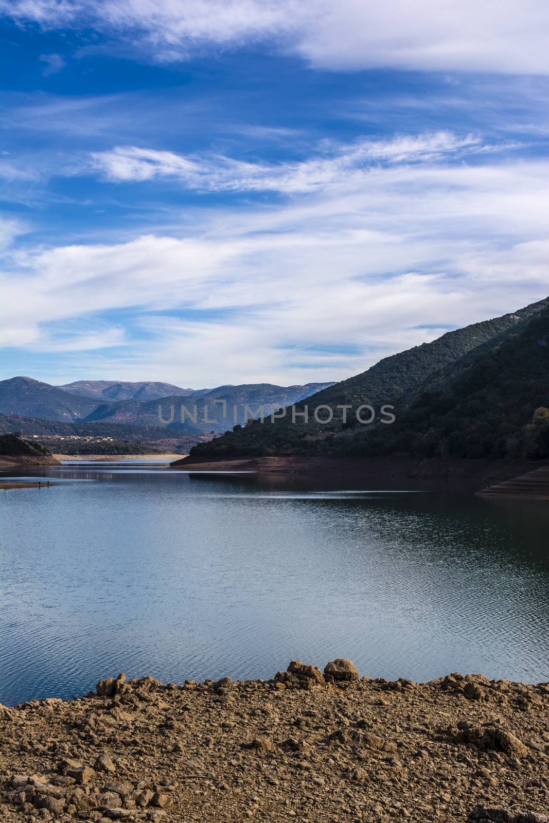 Ladonas artificial lake in Arcadia, Greece against a blue sky with clouds, and mountains as background