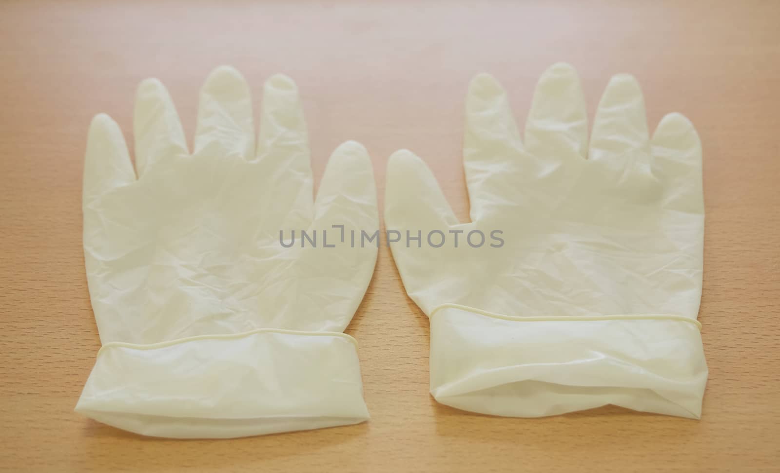 Pair of latex medical gloves on wooden table at counter nurse. 