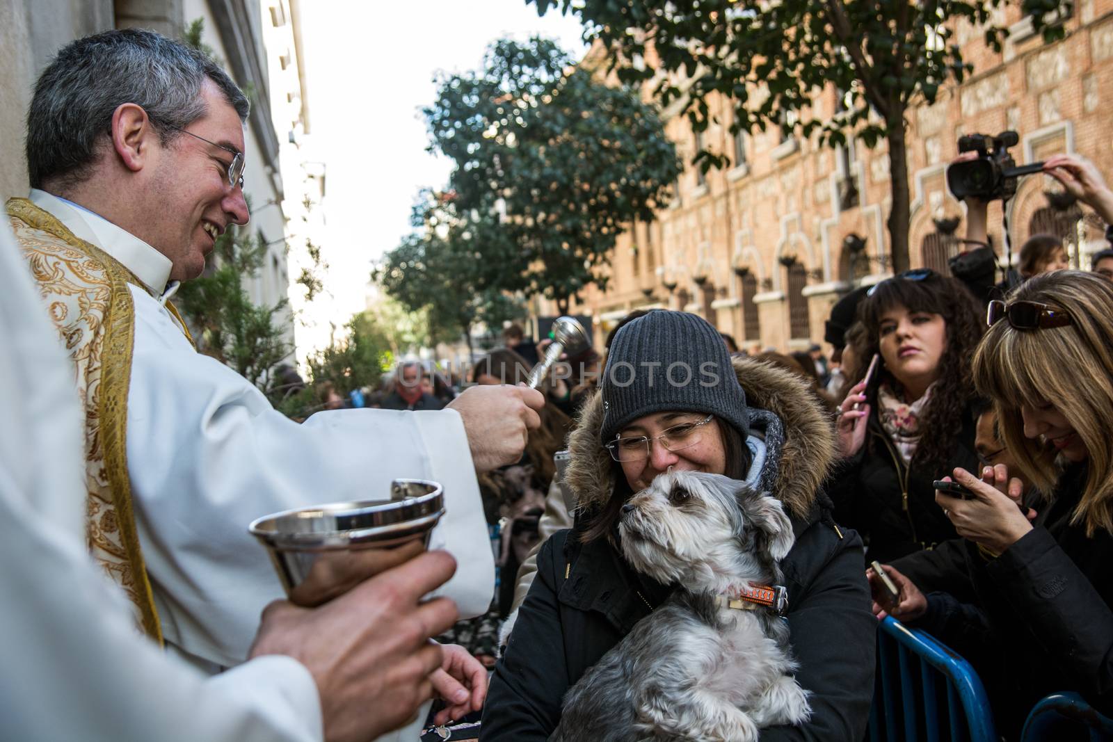 SPAIN, Madrid: A woman holds her dog while it is being blessed by a priest outside the church of San Antón in Calle de Hortaleza in Madrid on Saint Anthony's day, the patron saint of animals, on January 17, 2016.