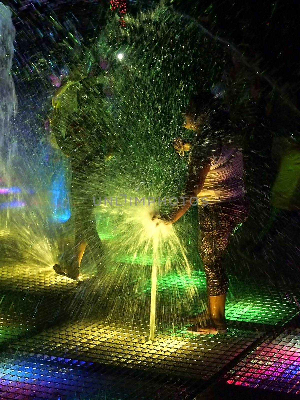 PERU, Lima: A child plays with water in a fountain as dozens of people assist to light and water show in front of the largest water wall of the world just inaugurated in the Park of the Reserve, Lima, Peru on January 15, 2016. 