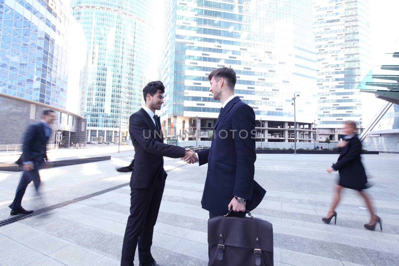 Business people shaking hands, finishing up a meeting outside office