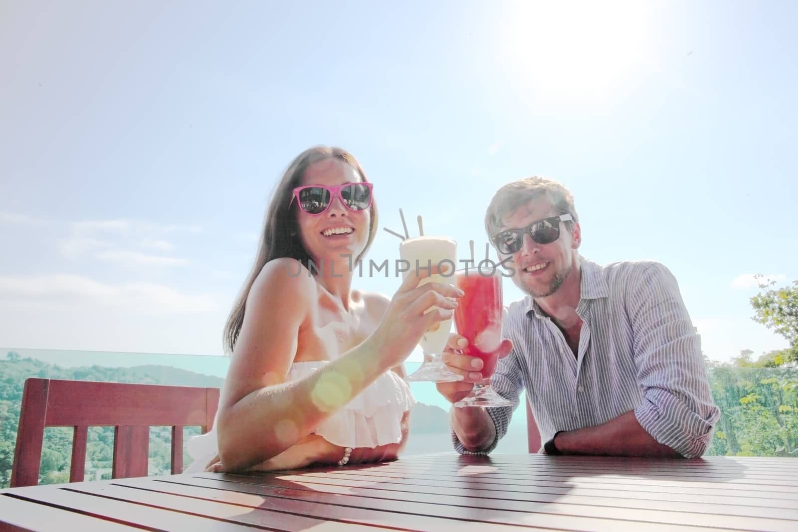 Happy couple enjoy their cocktails in outdoor cafe