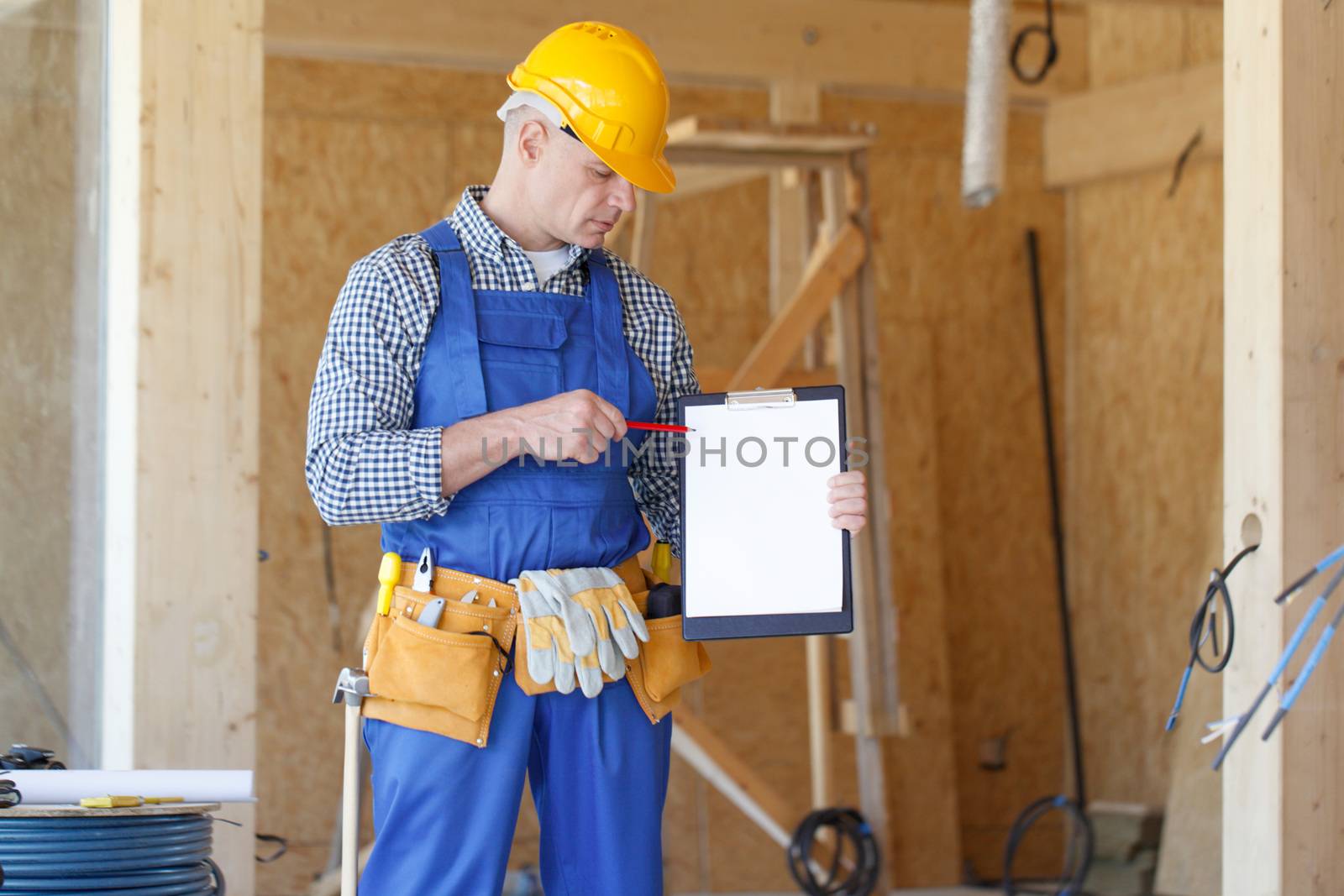 Portrait of foreman pointing at white folder plate