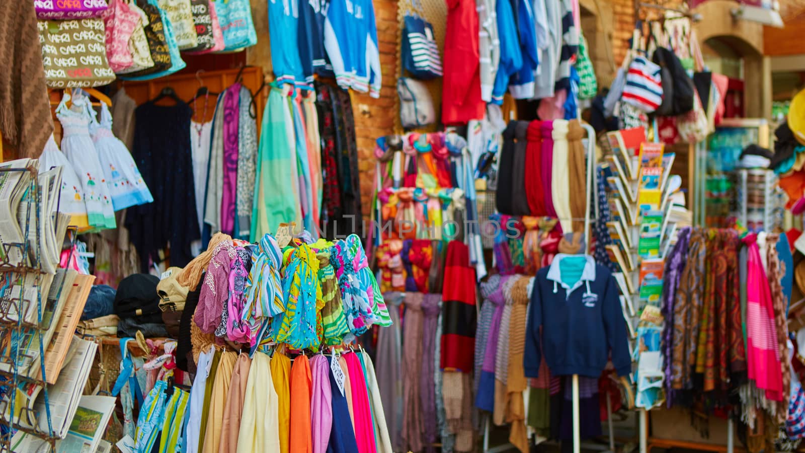 Rows of colourful silk scarfs hanging at a market stall in Sorrento, Italy