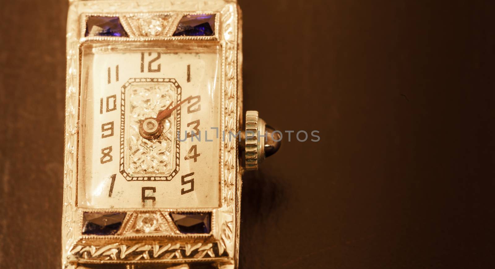 Antique luxury woman’s platinum watch with diamonds and sapphires on a black background