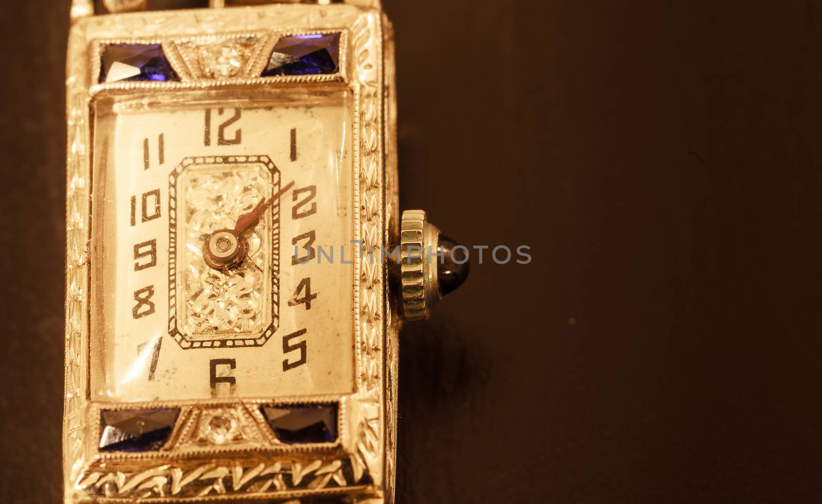 Antique luxury woman’s platinum watch with diamonds and sapphires on a black background