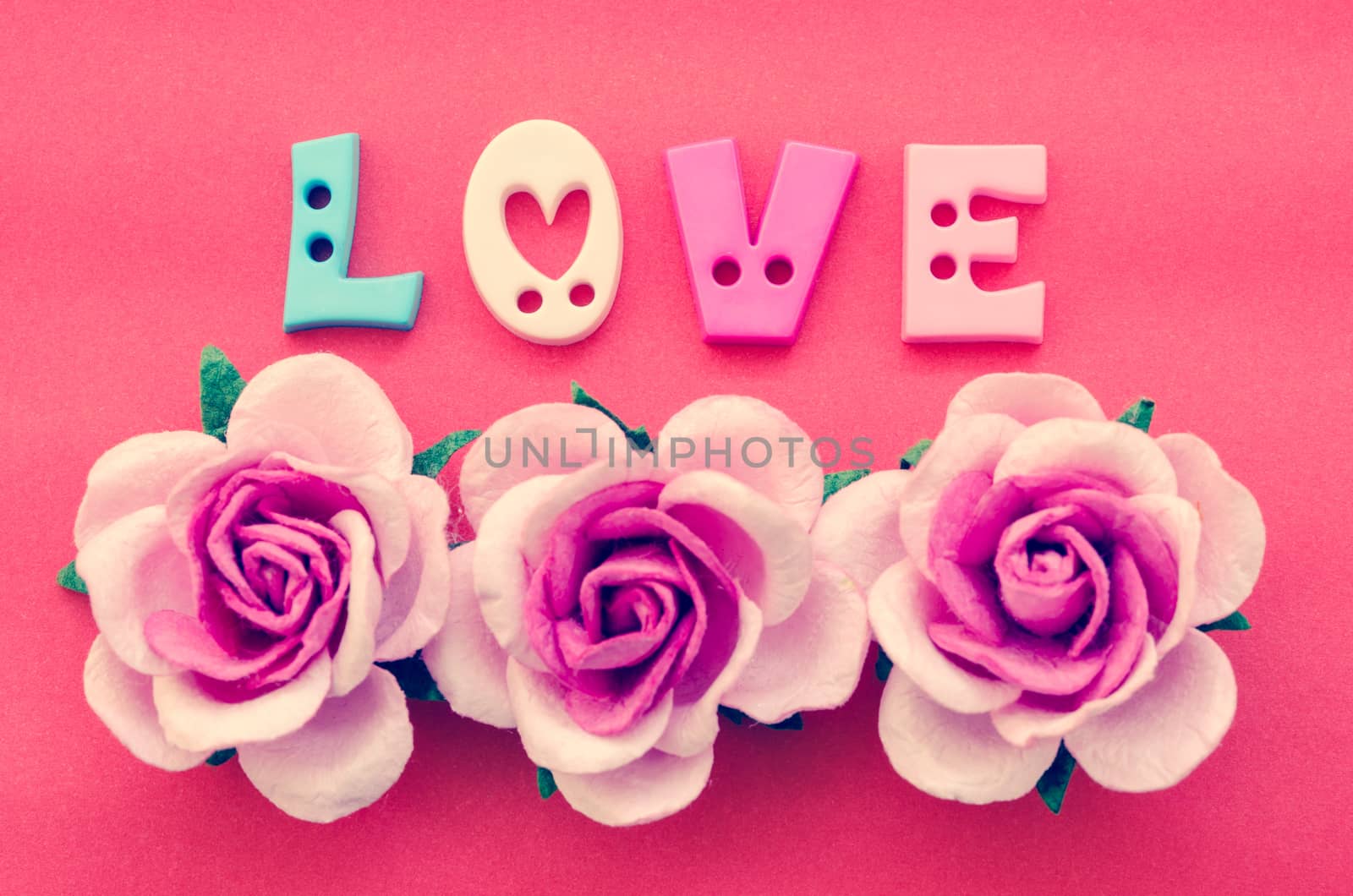 Vintage pink roses flower and love text on red background.