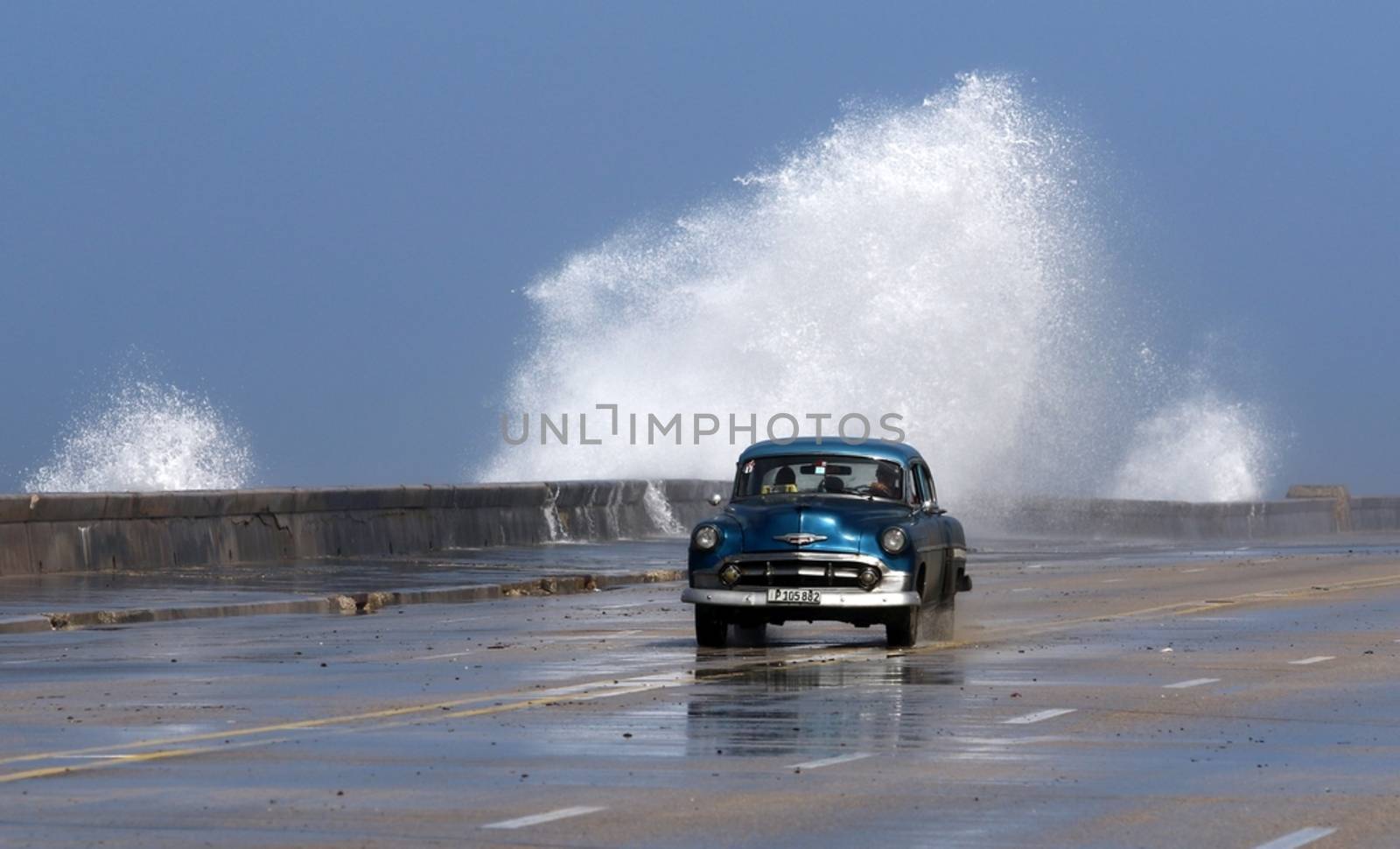 CUBA, La Havana: Vehicles drive through the flooded Malecon seawall in La Havana, Cuba, on January 17, 2016. Heavy seas invaded the Havana coastline along the Malecon seawall. 