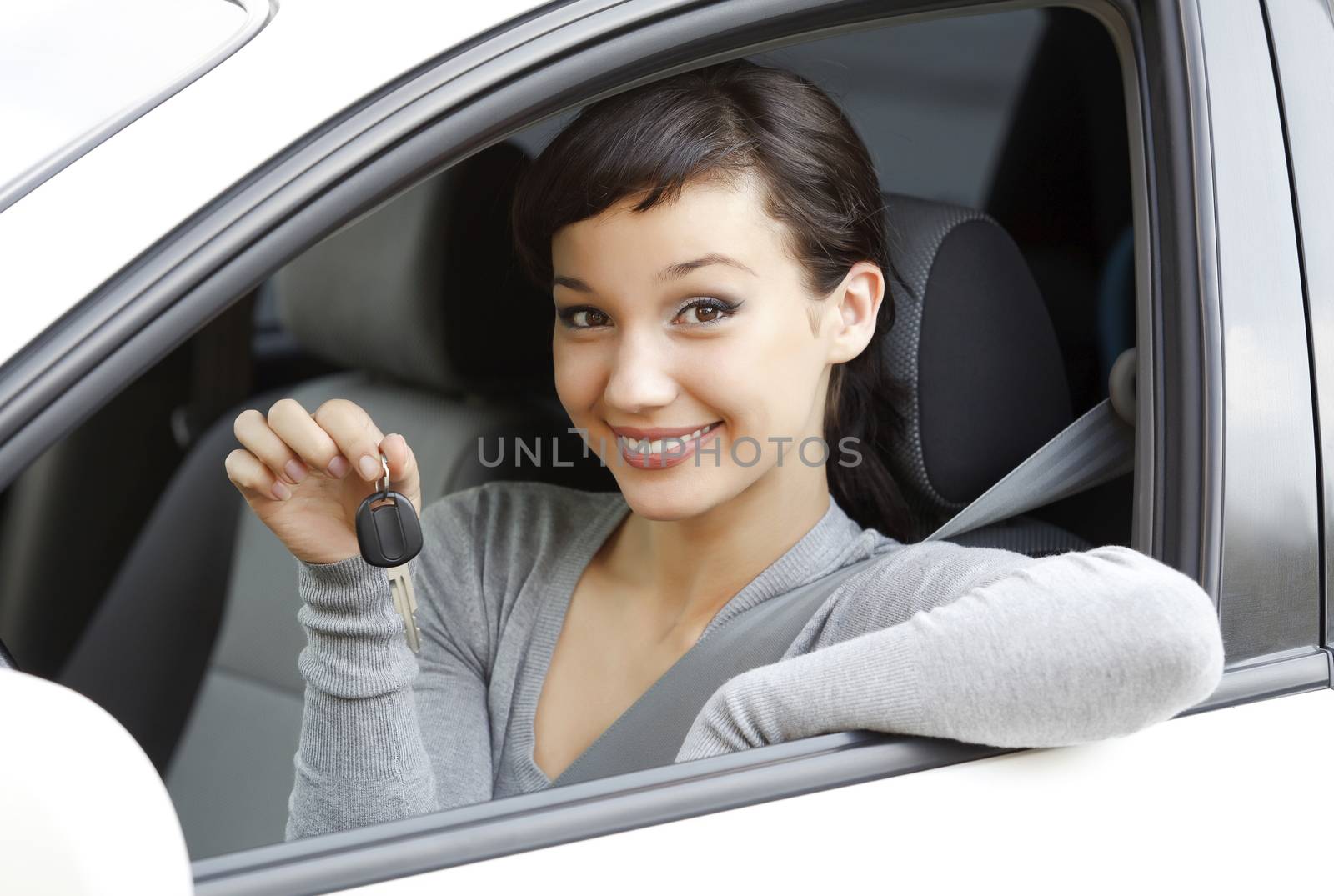 Pretty girl in a car showing the key