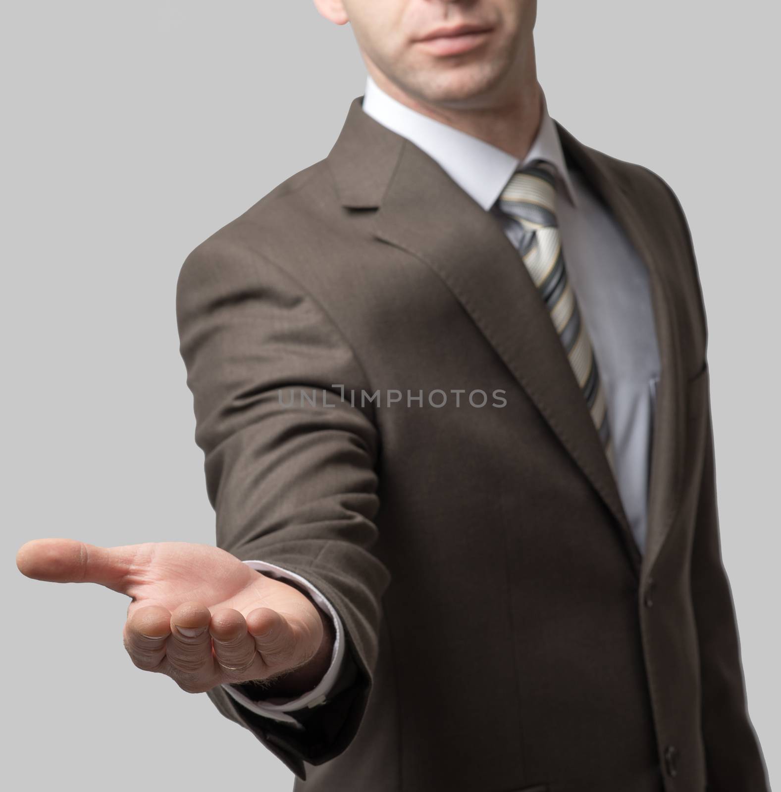 Businessman with outstretched empty right hand on grey background