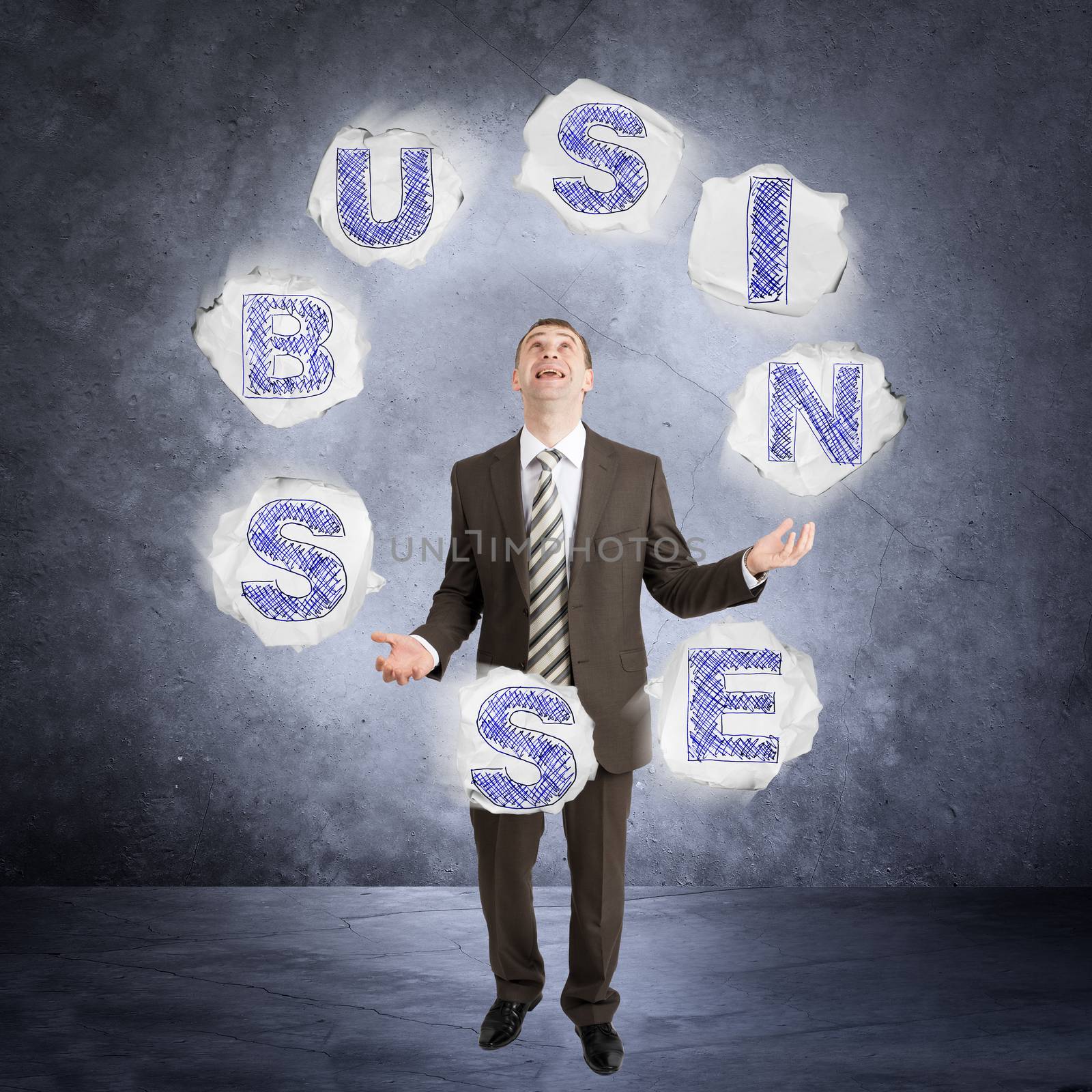 Businessman juggling word business on abstract grey background