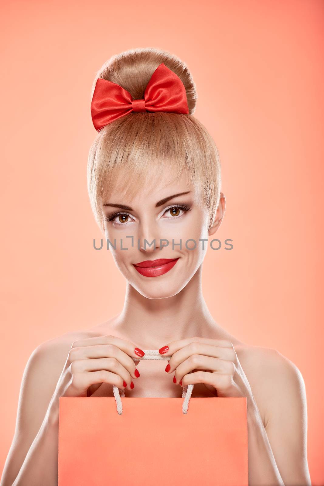 Beauty fashion portrait loving woman smiling with shopping bag. Confidence sensual attractive pretty nude blonde sexy girl, Pinup hairstyle, red bow. Unusual playful. Romantic on pink, sale, discount