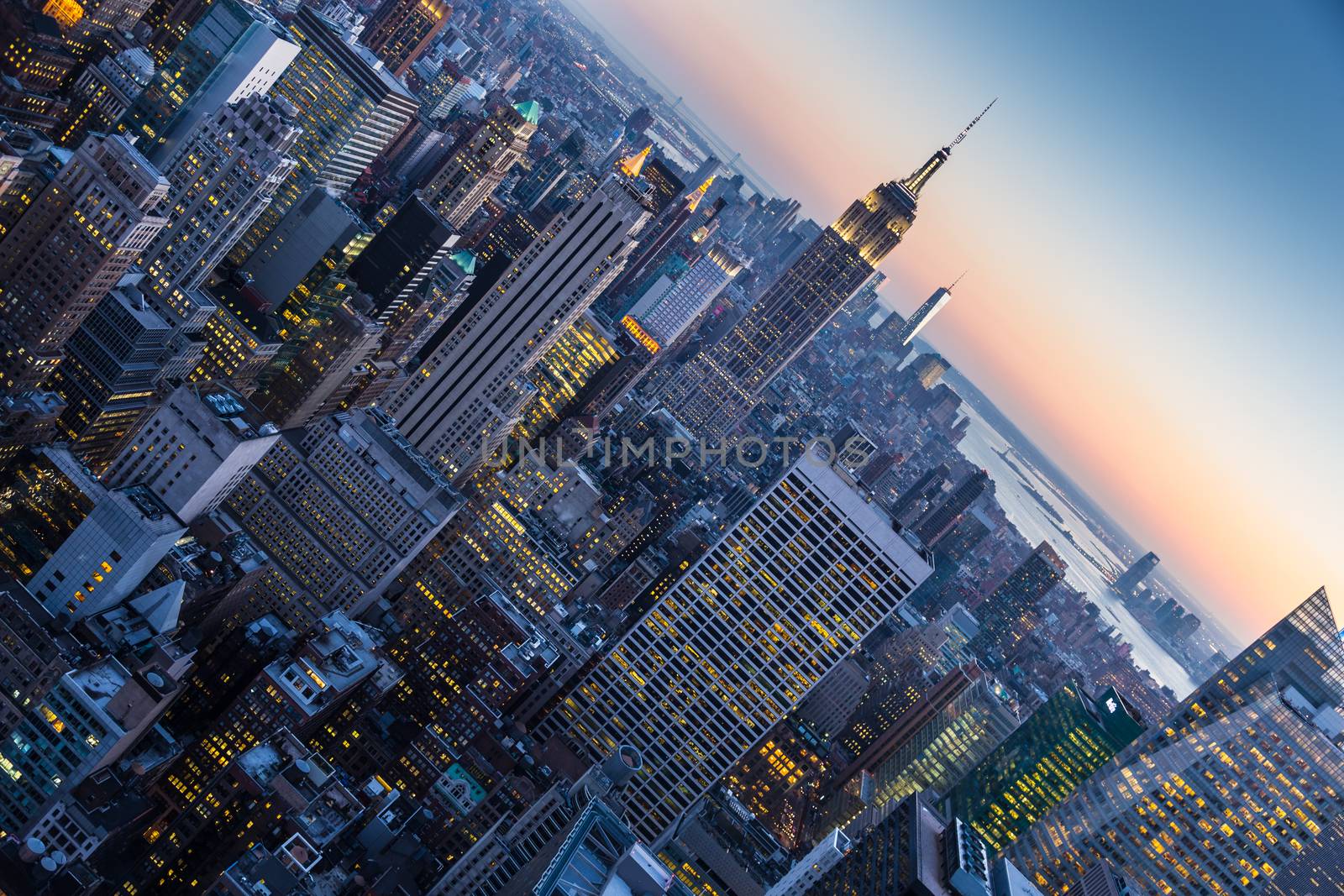 New York City. Manhattan downtown skyline with illuminated Empire State Building and skyscrapers at dusk.