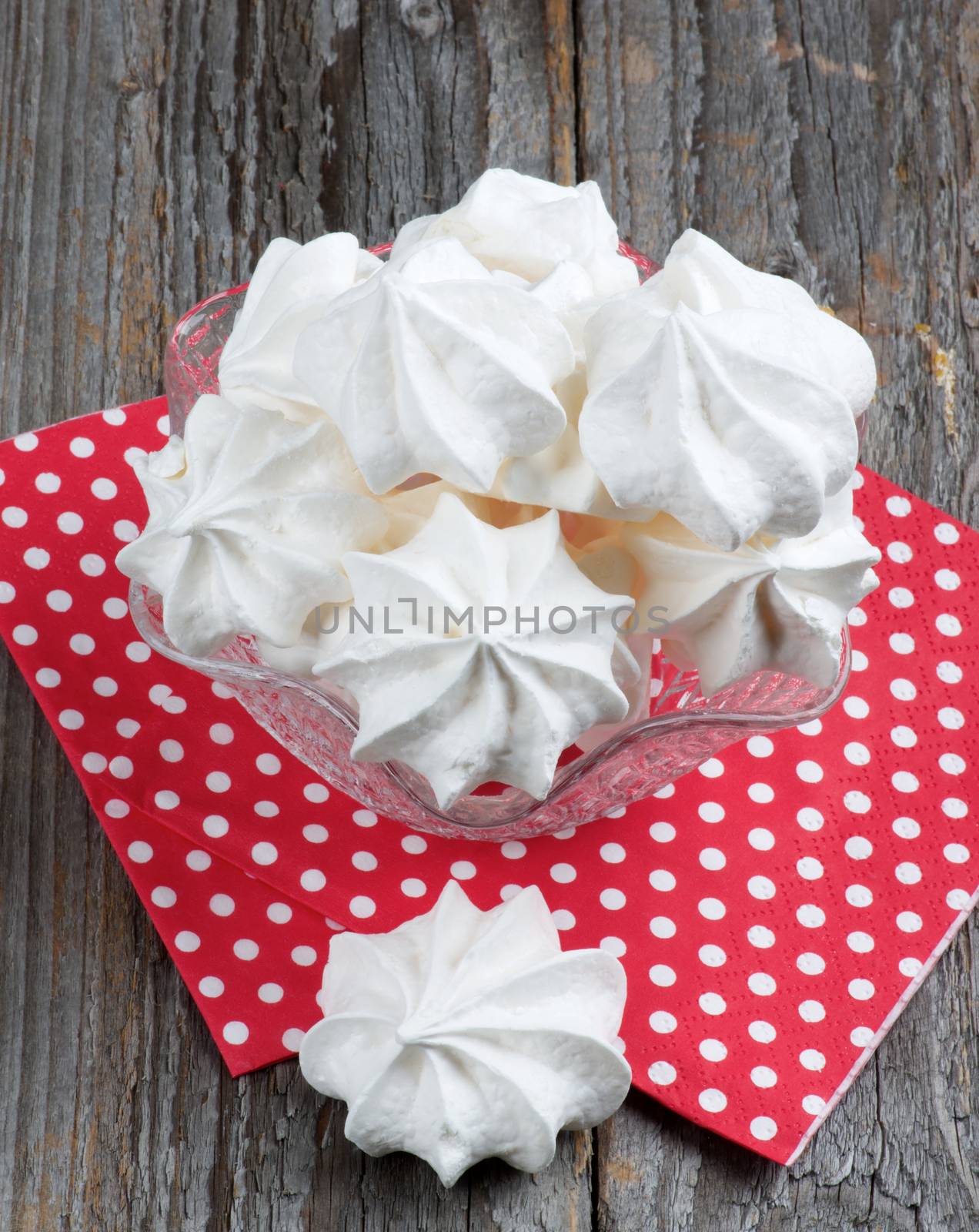 White Meringue Cookies in Dessert Vase on Red Polka Dot Napkin closeup on Rustic Wooden background