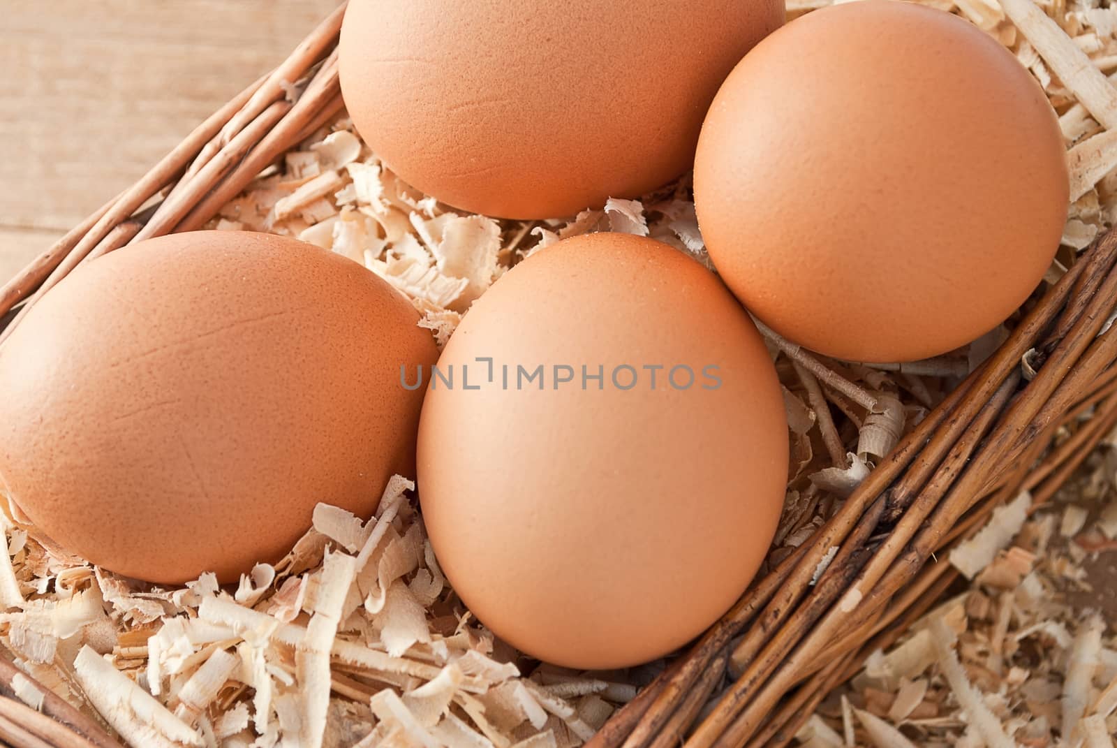 Egg on sawdust with old basket over on wooden background  by rakoptonLPN