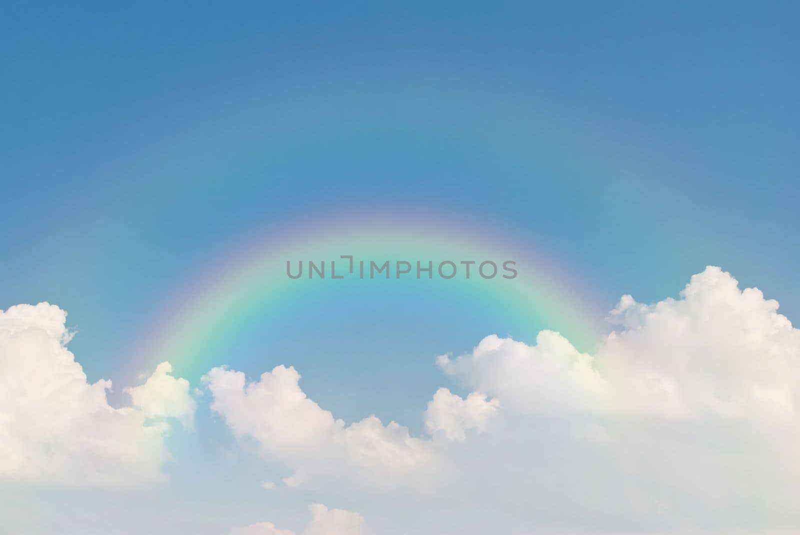 image of rainbow in blue sky and white clouds by rakoptonLPN