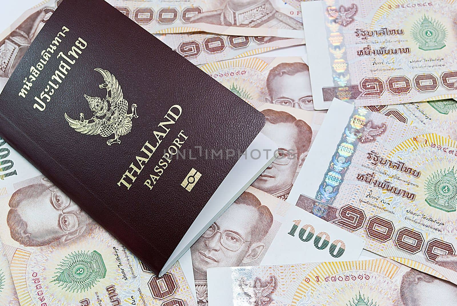 Thailand passport with Thai money ready to travel on white background by rakoptonLPN