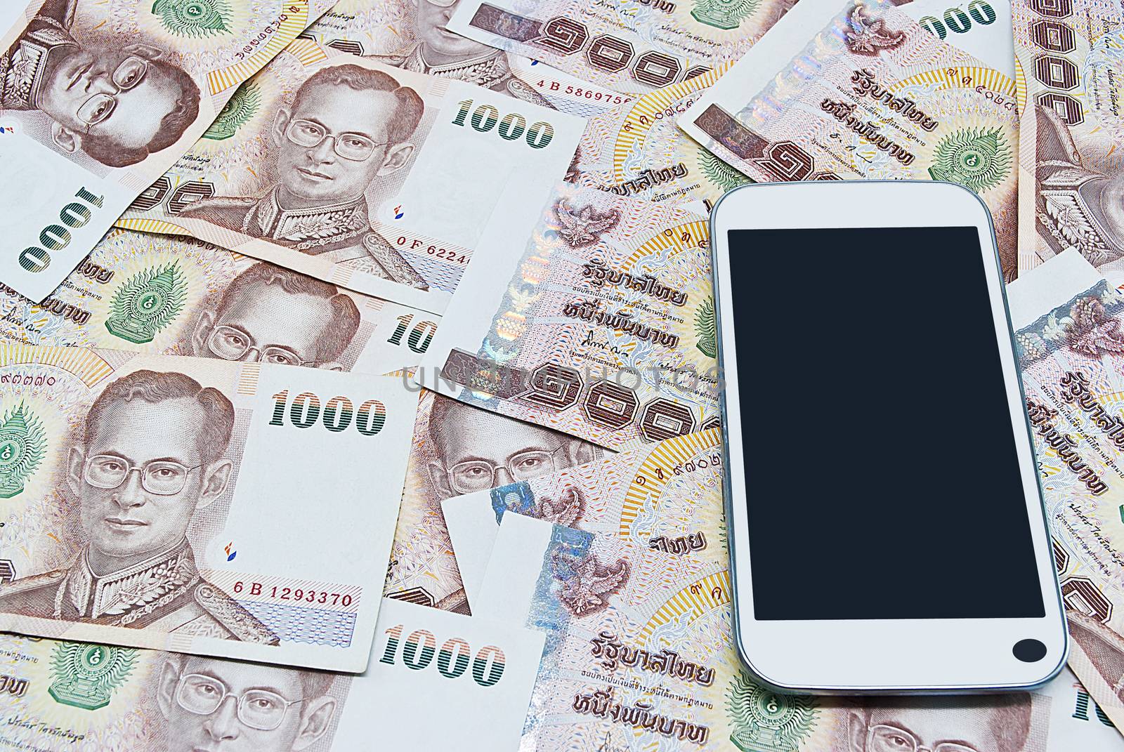 smartphone on thai banknote for background by rakoptonLPN