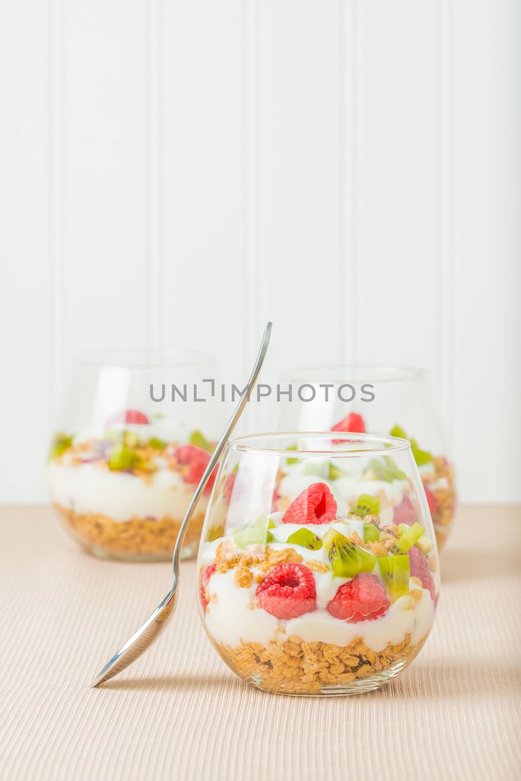 Glasses filled with parfait consisting of granola, yogurt and fresh fruit.
