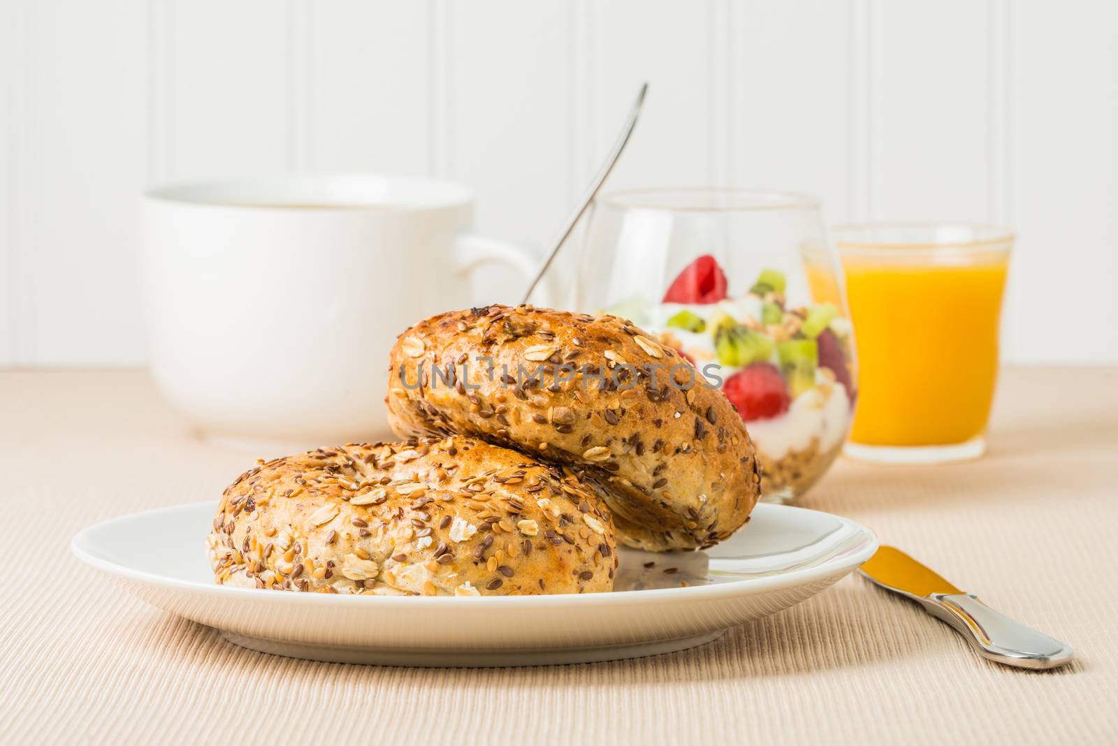 Fresh muesli bagels served with fruit, coffee and juice.