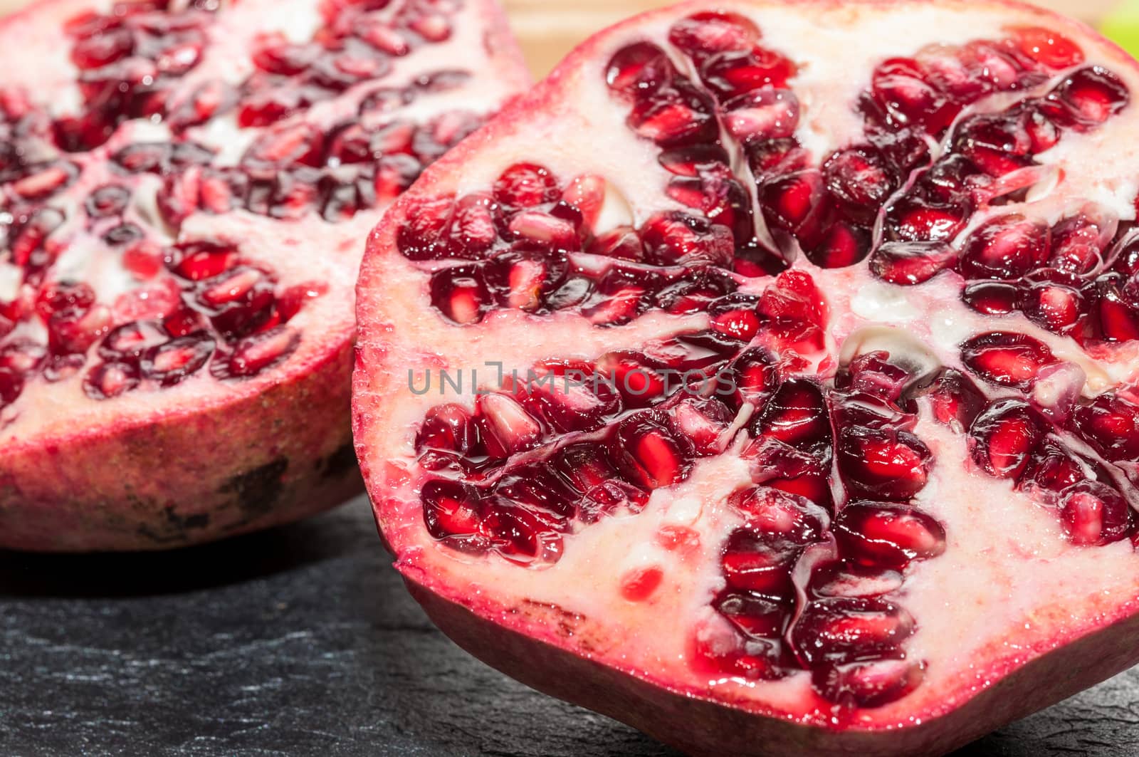 Seeds of pomegranate on a slate background