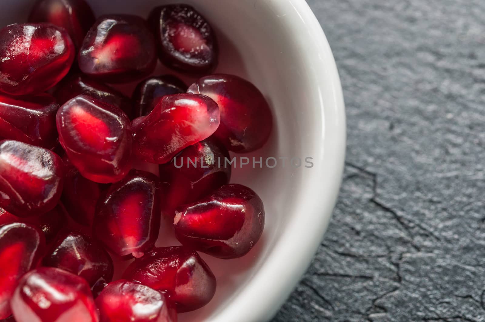 Seeds of pomegranate on a slate background