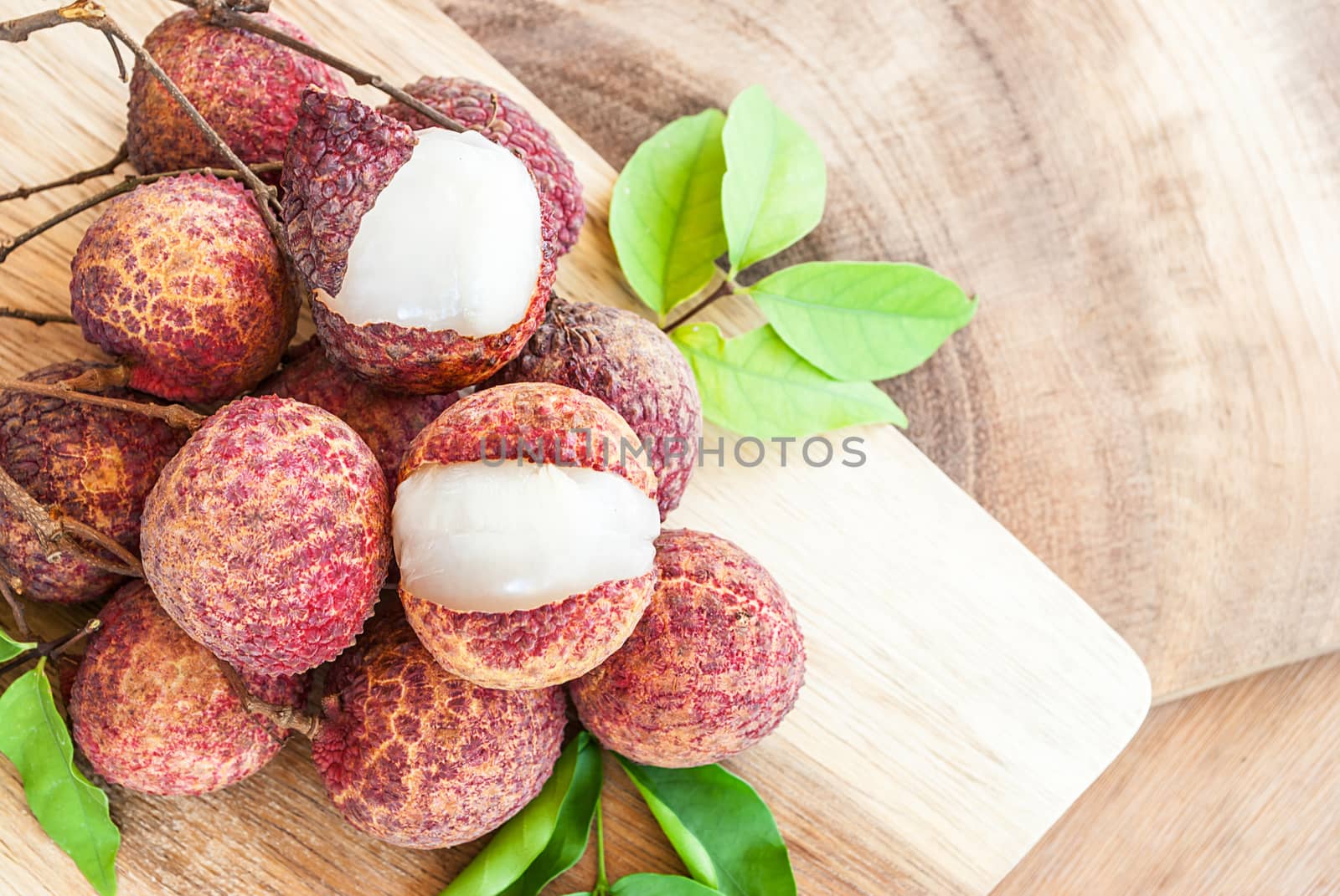 Closeup of lychee fruits on wooden board, fruits of asian