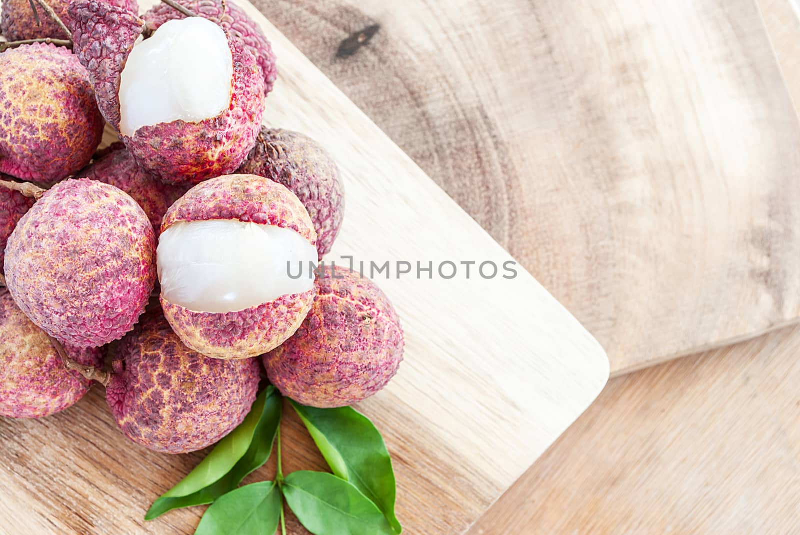 Closeup of lychee fruits on wooden board, fruits of asian by rakoptonLPN