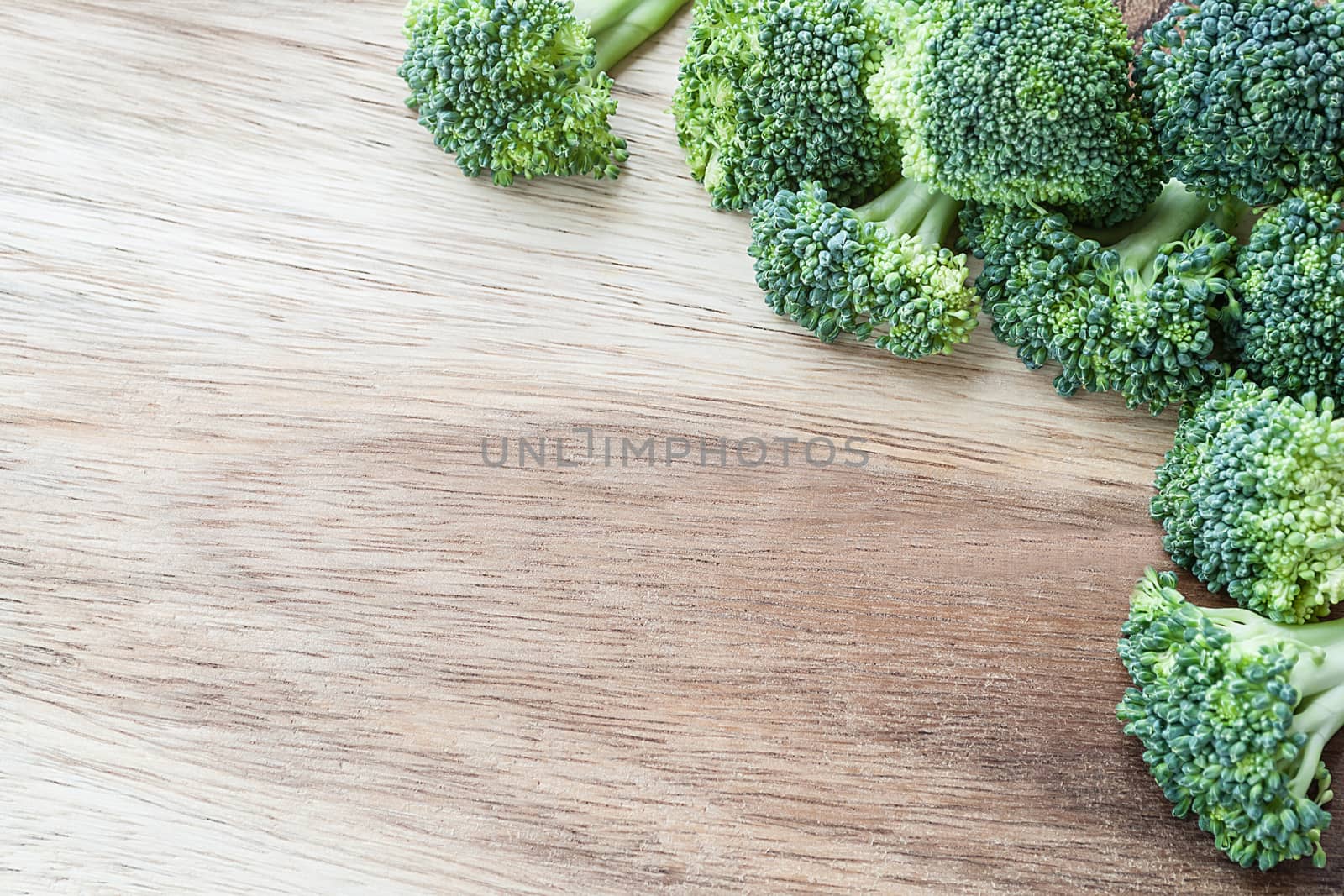 Fresh broccoli on wooden board for background by rakoptonLPN