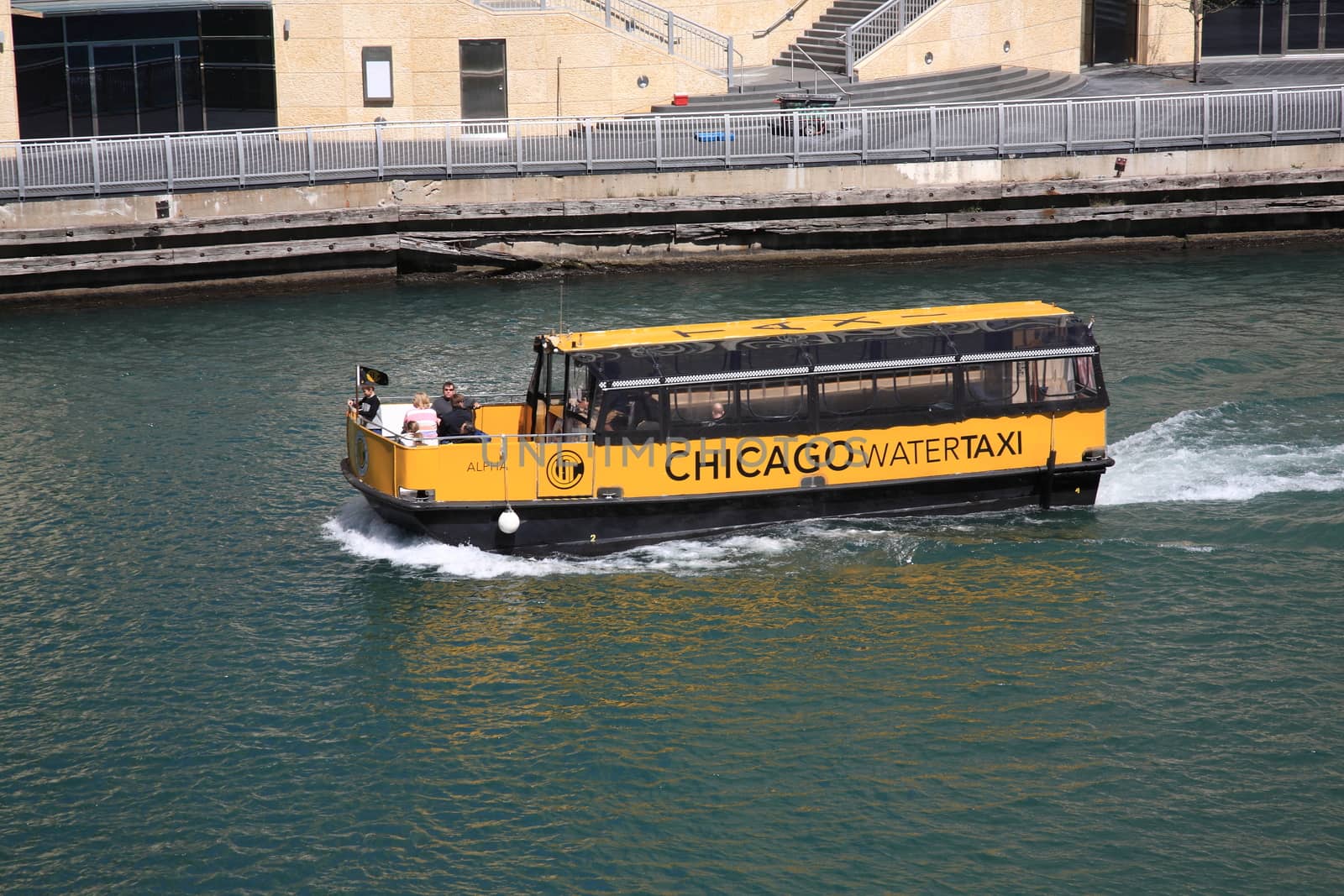 Tourists tour the skyscrapers of Chicago as they ride the Chicago River in a water taxi.