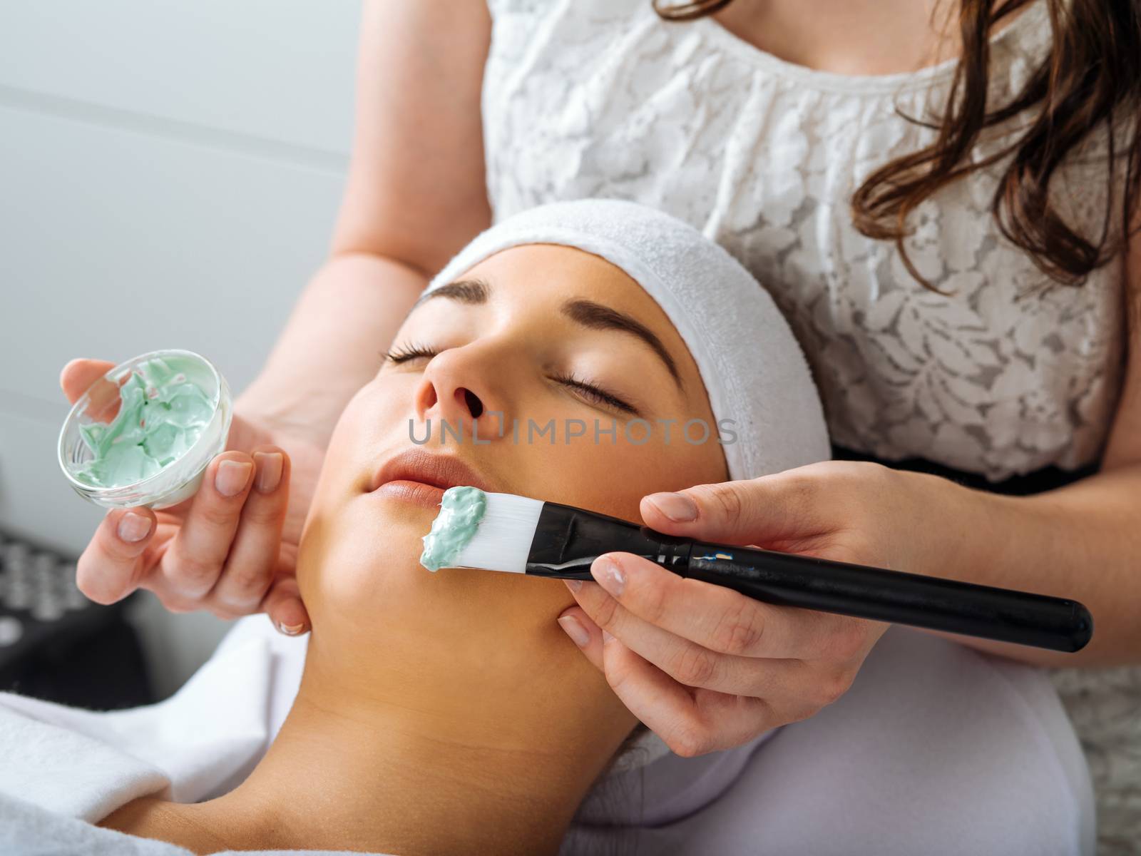 Young woman having a facial in the salon by sumners