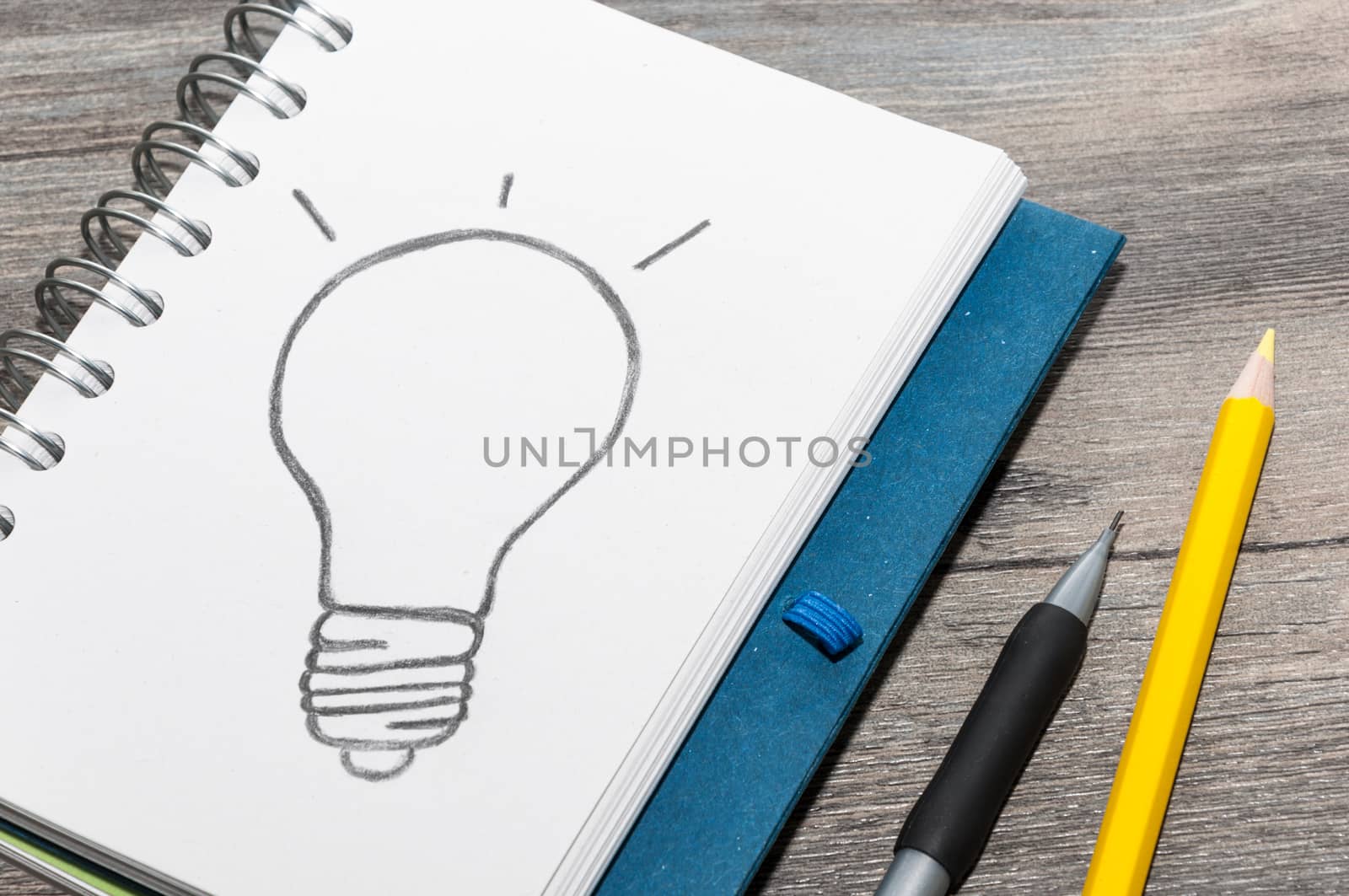 Office supplies and an open book with a drawing of a light bulb