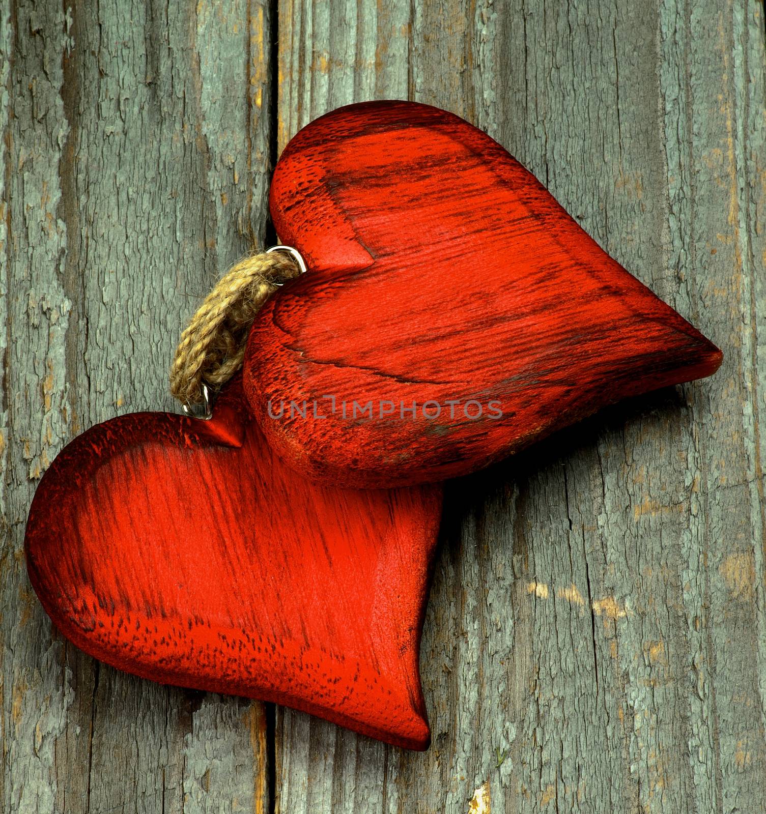 Valentine Theme Background with Two Handmade Wooden Red Hearts closeup on Rustic Wooden background