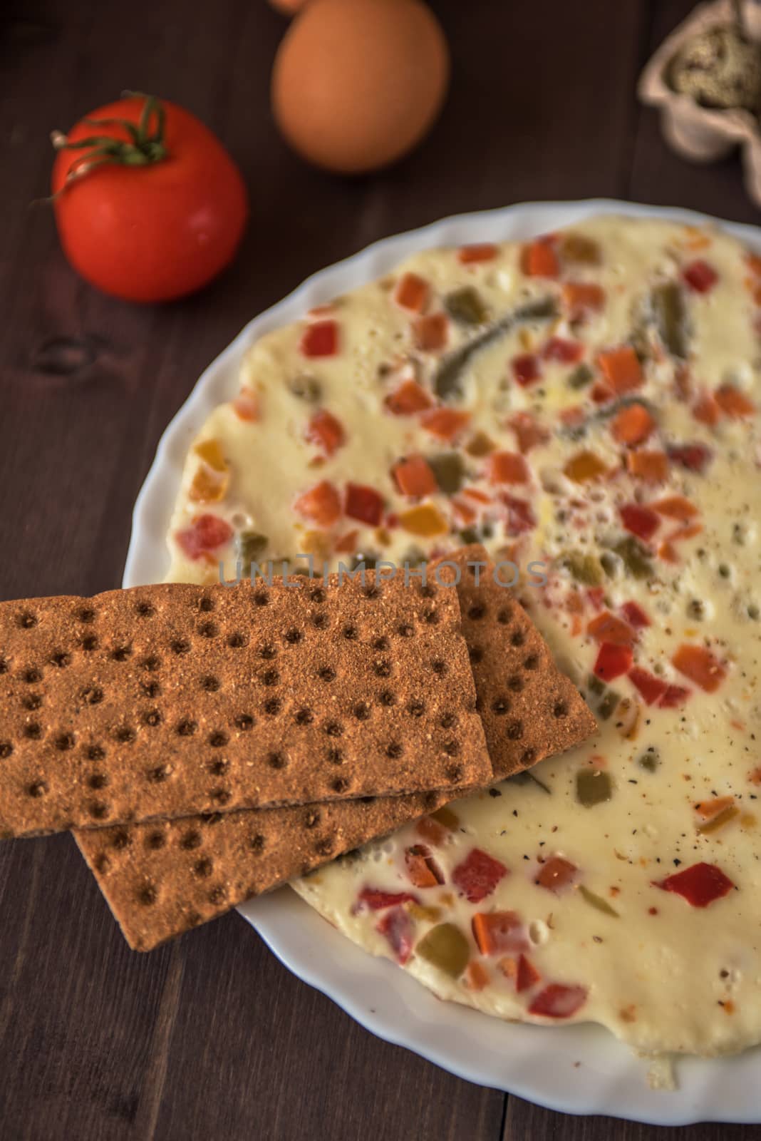 baked omelette with different eggs and vegetables with rye small load of bread