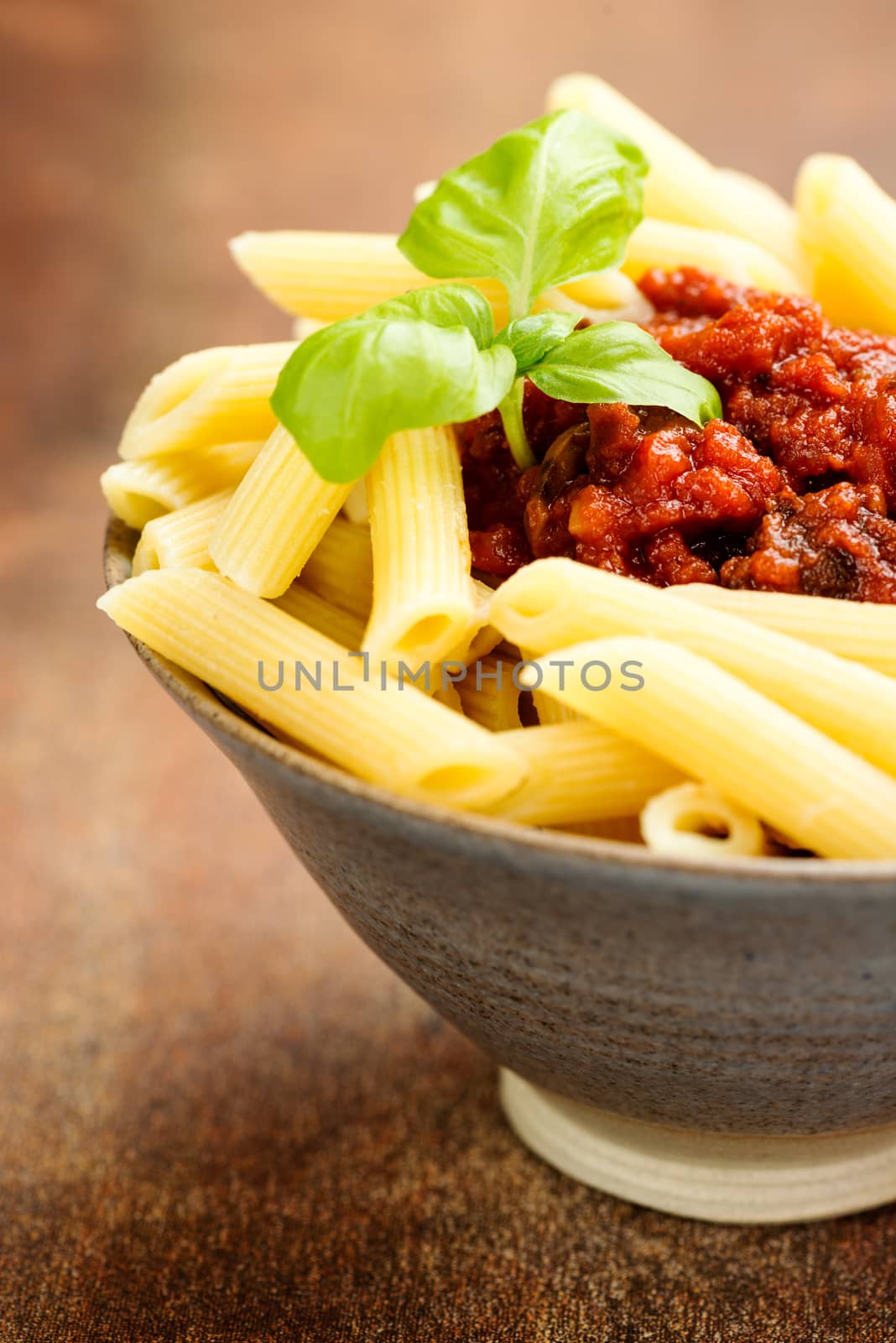 Penne pasta with a tomato bolognese beef sauce on the table