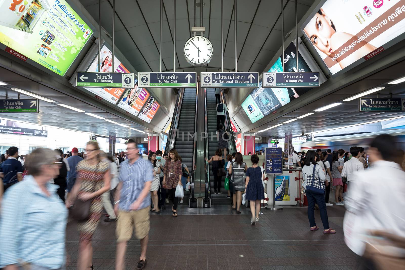 Bangkok, Thailand - January 18, 2016 : crowd of people at BTS Siam station some people waiting for the train and some people using the escalator that has advertising along the way in the rush hour evening. Daily passengers of BTS skytrain is around 700,000