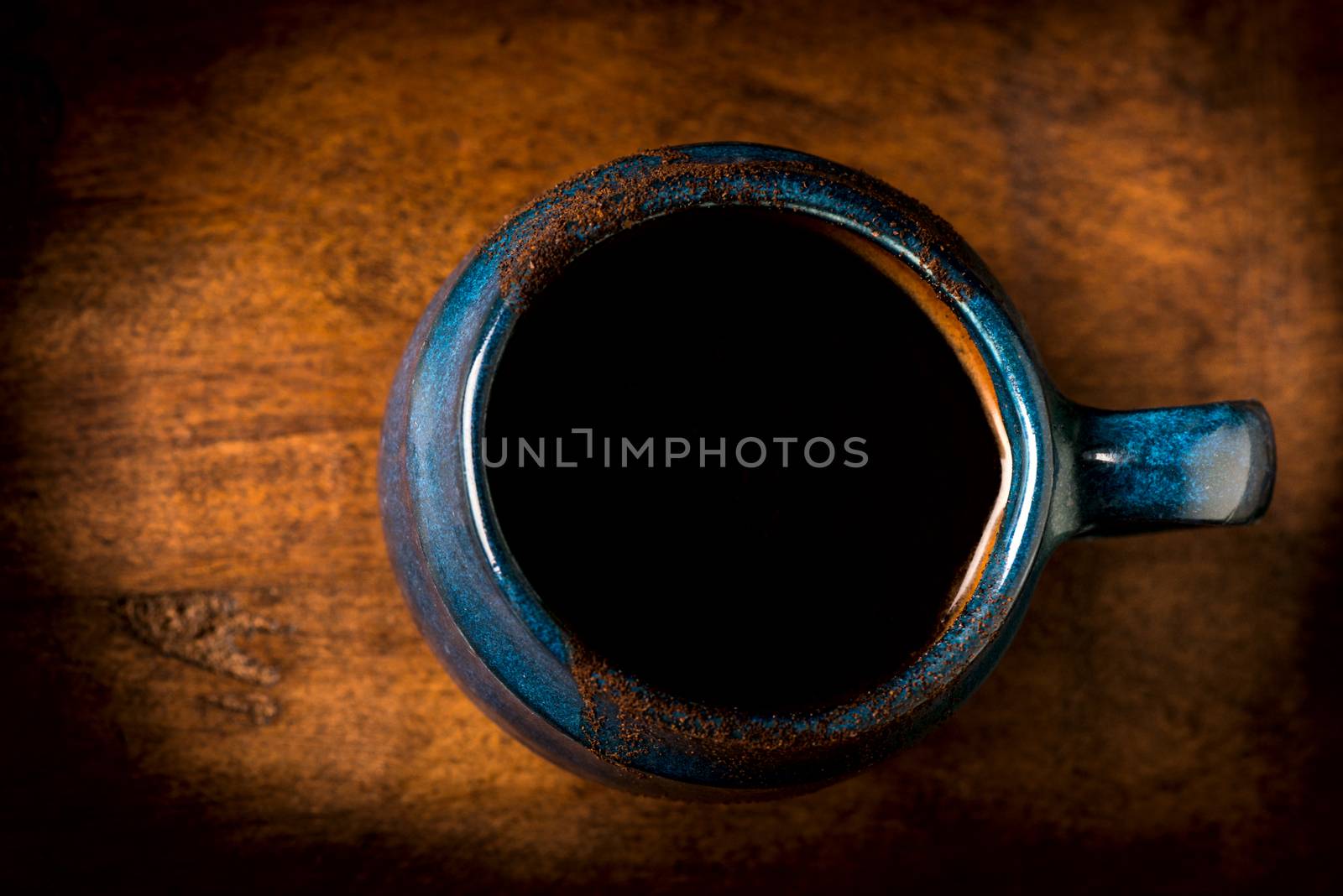 Coffee in grunge blue clay cup on rustic wooden background