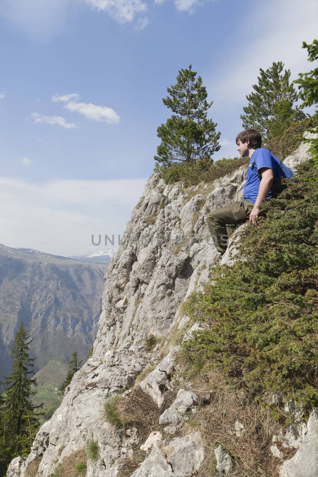 Young backpacker sitting on the edge of a cliff
