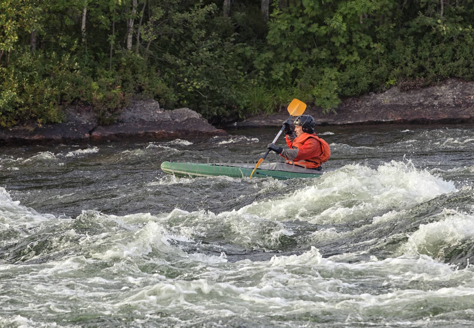 Kayaker in the  whitewater of a river Umba in Russia